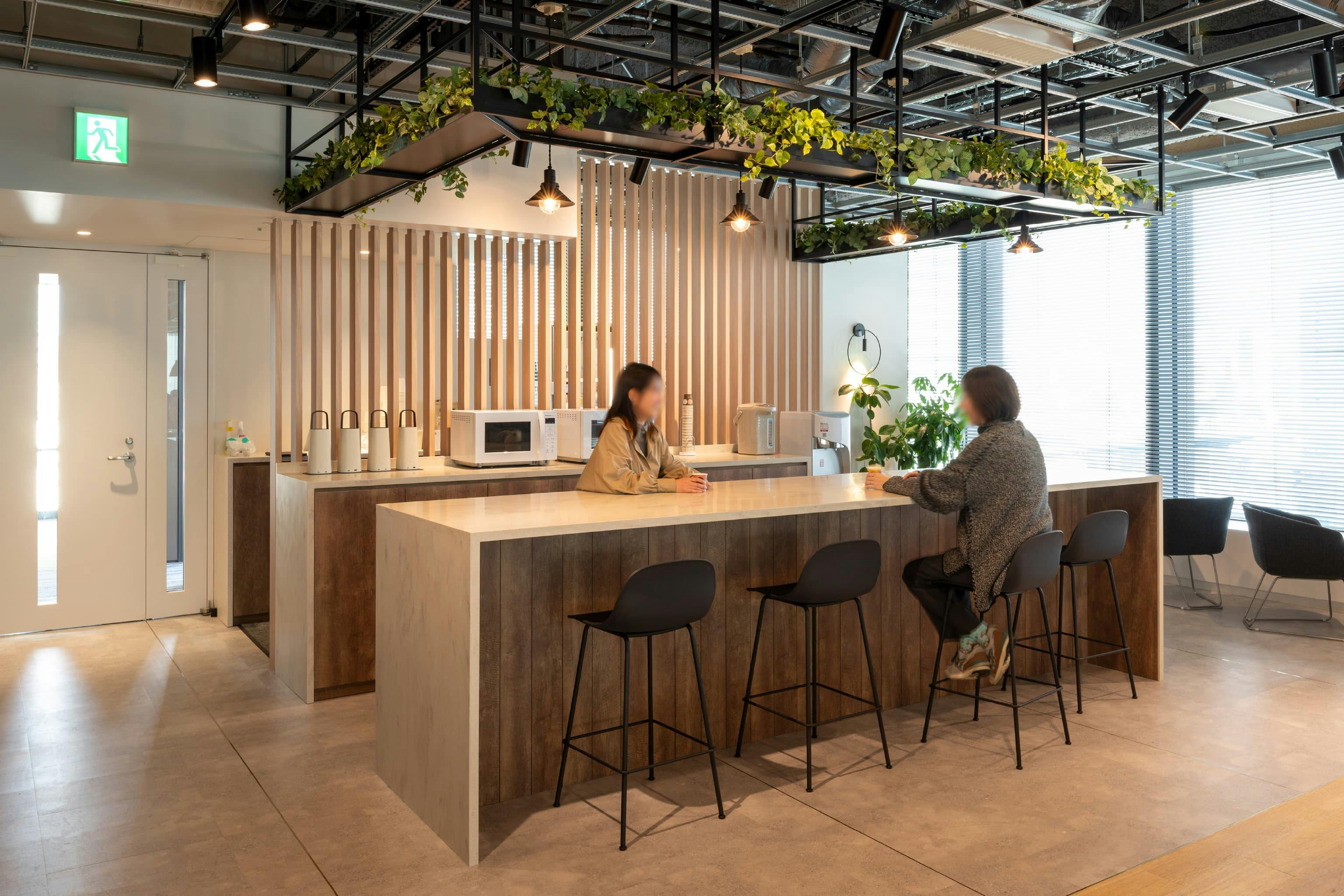 ハニューフーズ株式会社 様の事例写真／[多目的室]カウンターは、軽食やドリンクを楽しんだり、一息ついたりできるカジュアルな憩いの場。ふと立ち寄った人同士が自然に言葉を交わし、社内のつながりを広げます。