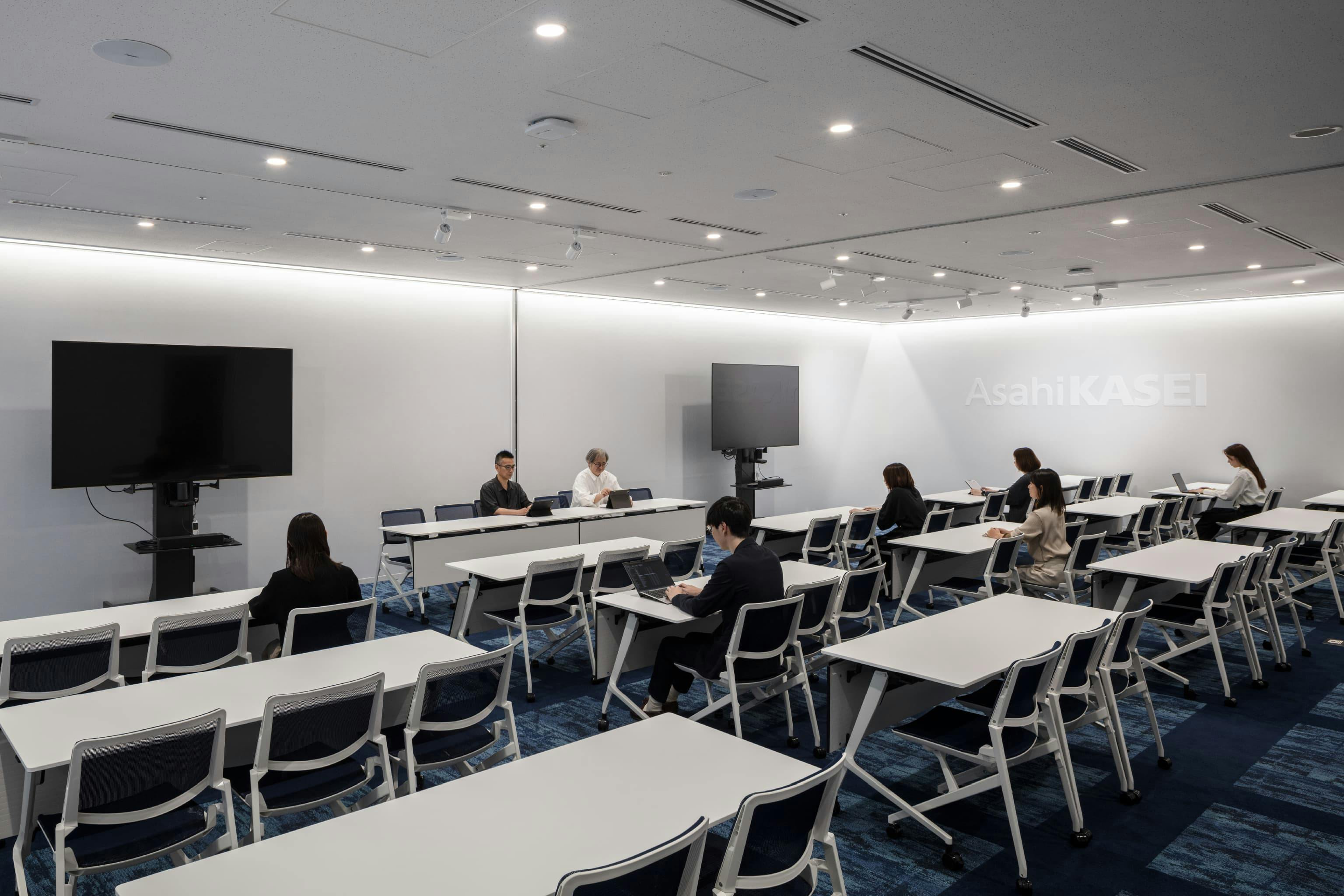 旭化成株式会社 様の事例写真／[プレゼンテーションルーム]最大78席を備え、大規模な会議や記者会見、決算発表の場として利用されています。青を基調としたカーペットは大海原を思わせ、次の100年へ向けた力強い航海をイメージさせます。