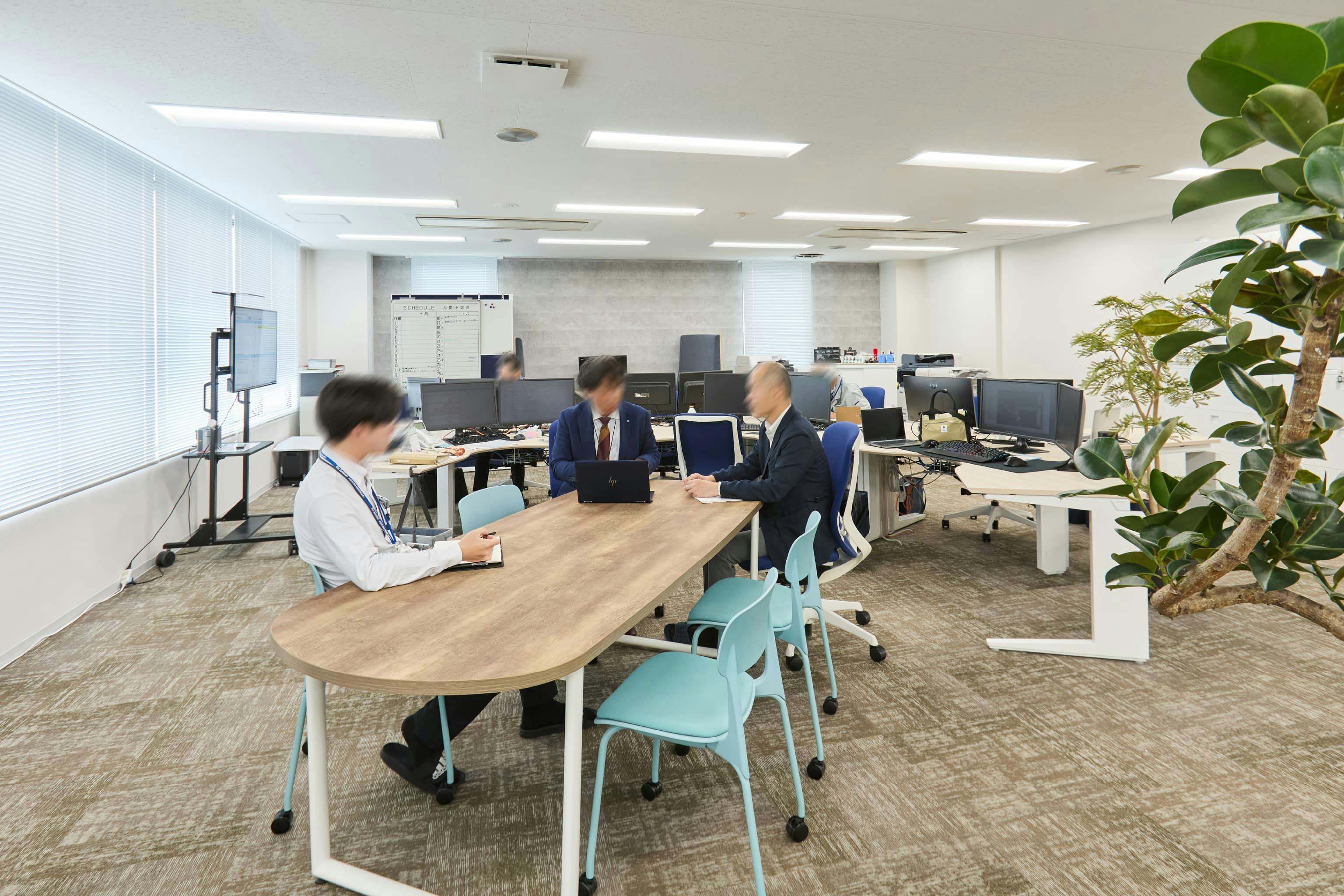 株式会社荒谷建設コンサルタント 様の事例写真／[2F執務スペース]視界を遮る背の高い什器がなく、見通しのよい広々とした空間。ちょっとした打ち合わせに使われる長テーブルは、大きな図面を広げるのにもちょうどよいサイズです。