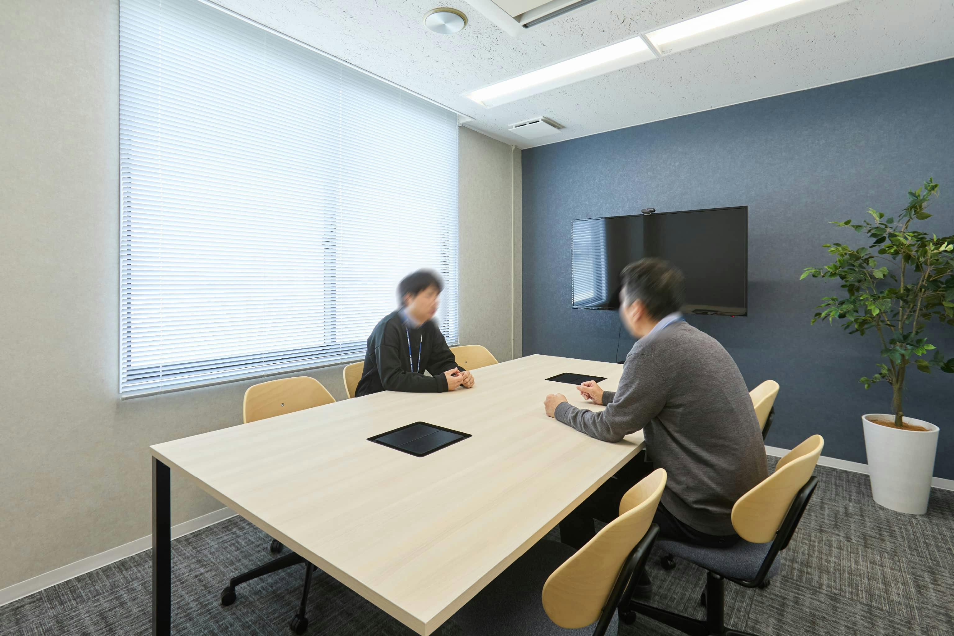 株式会社荒谷建設コンサルタント 様の事例写真／[4F会議室]執務スペースの横にある会議室。壁の色は、2階が深緑色だったのに対して、4階は落ち着いた印象のグレーを採用し、冷静な議論の場となっています。
