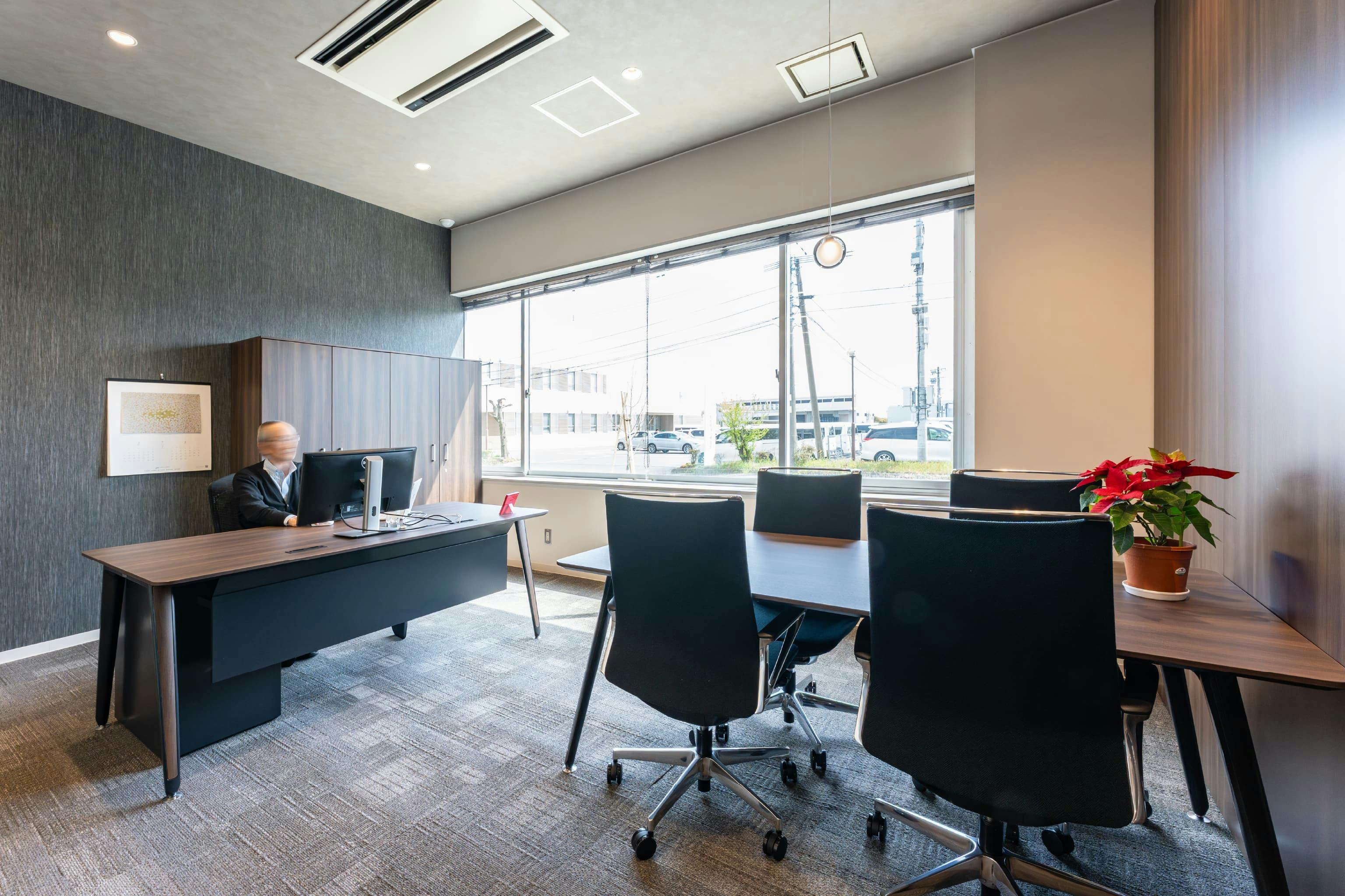 株式会社清永宇蔵商店 様の事例写真／[会長室]暗めの色を基調とした重厚感のある空間ですが、大きな窓があるため、明るさや開放感は確保されています。来客が多いため、会談用のテーブルも用意されています。