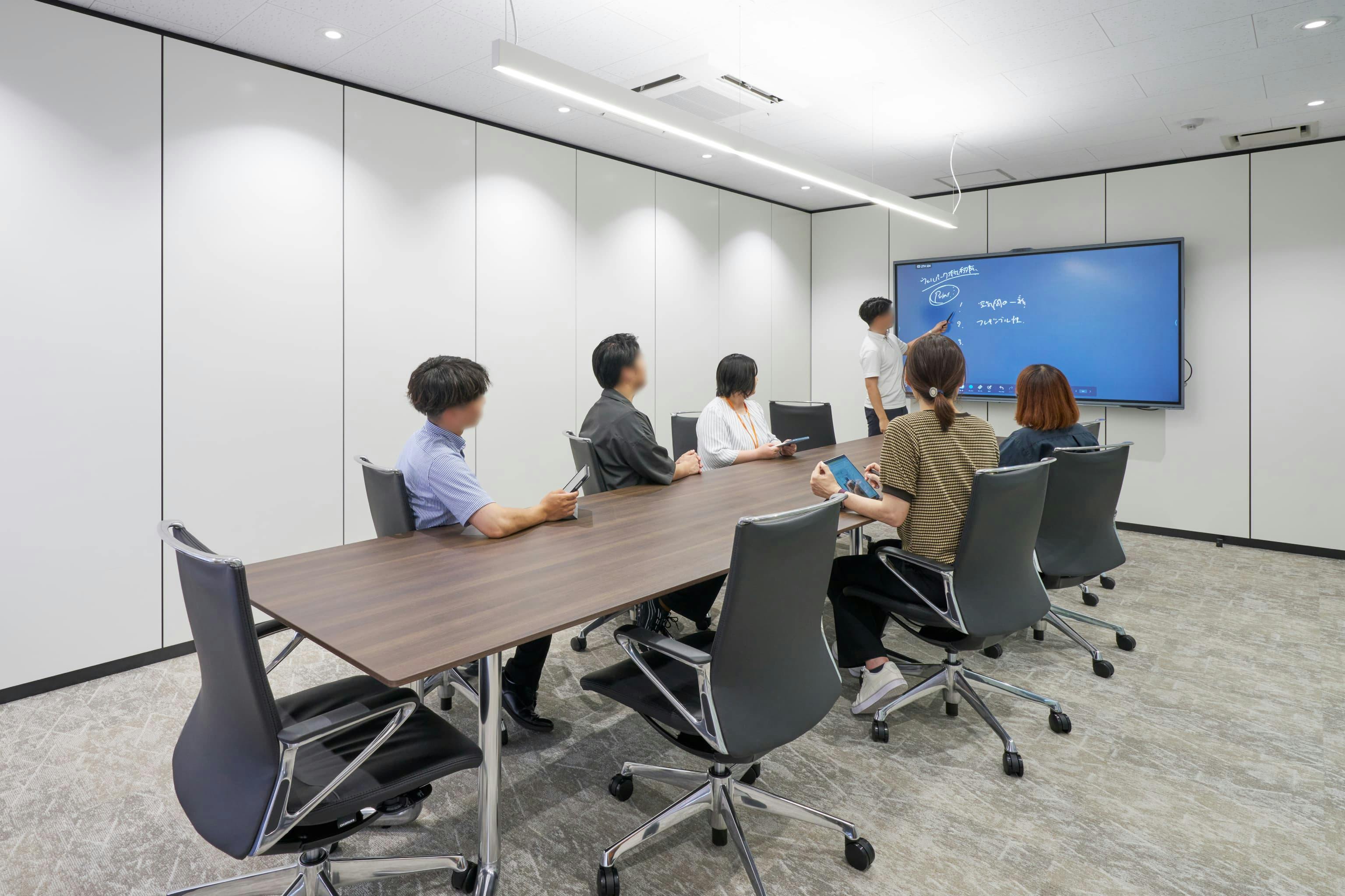 株式会社ウェルパーク 様の事例写真／[役員会議室]取締役のレセプション対応や重要な打ち合わせに使用。革張りチェアとポリッシュ脚の輝きが上質感を添え、一枚天板のテーブルが洗練された印象を与えます。WEB会議やホワイトボードの機能を有したインタラクティブディスプレイの導入で、機能性も高められています。