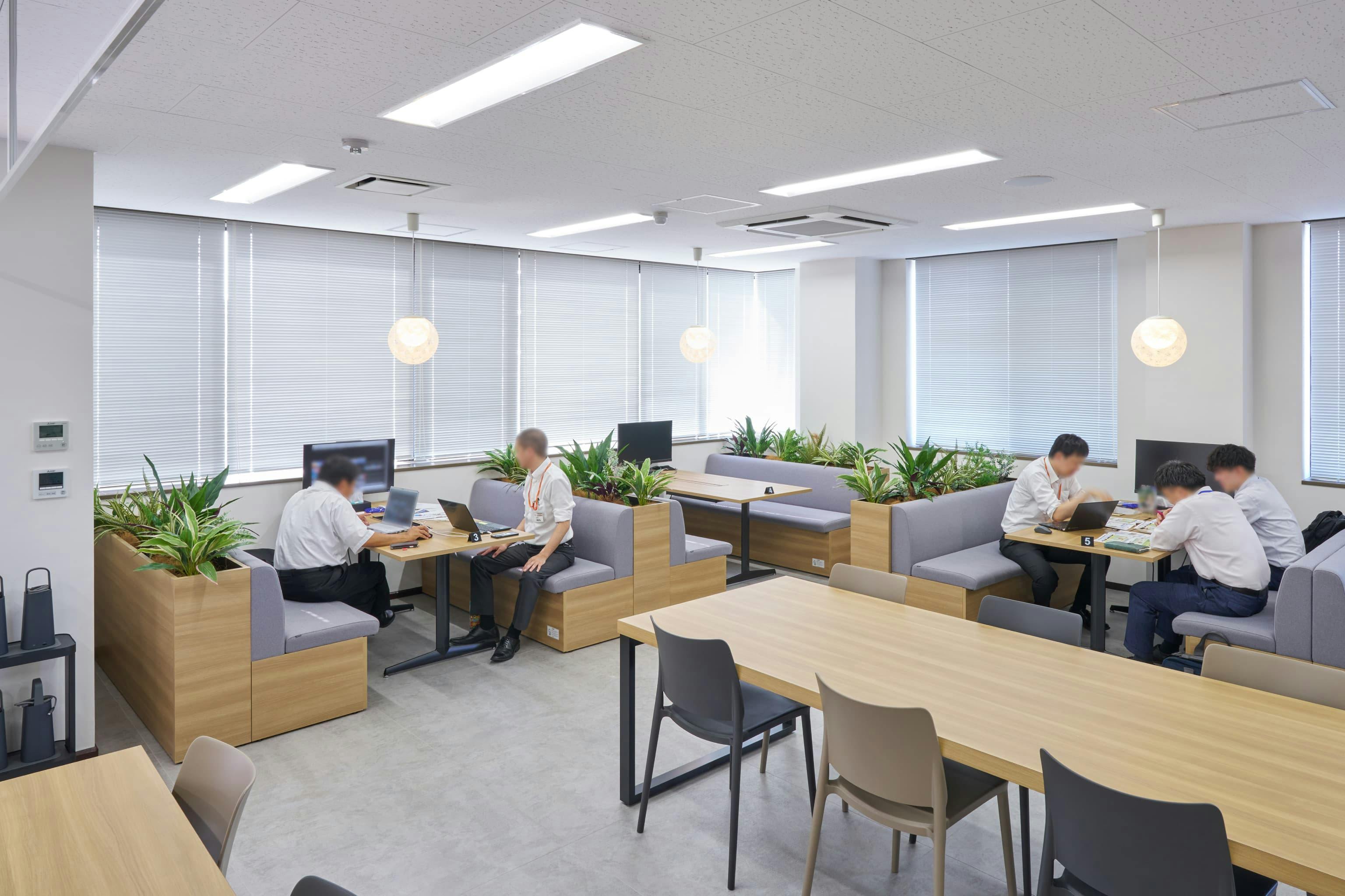 株式会社ウェルパーク 様の事例写真／[リフレッシュエリア]エントランス近くに位置し、来訪者を案内しやすいエリア。社外との打ち合わせにも活用されており、モニター付きのファミレス席は予約が可能です。OCポータブルバッテリーが、働く場所の自由度を高めています。