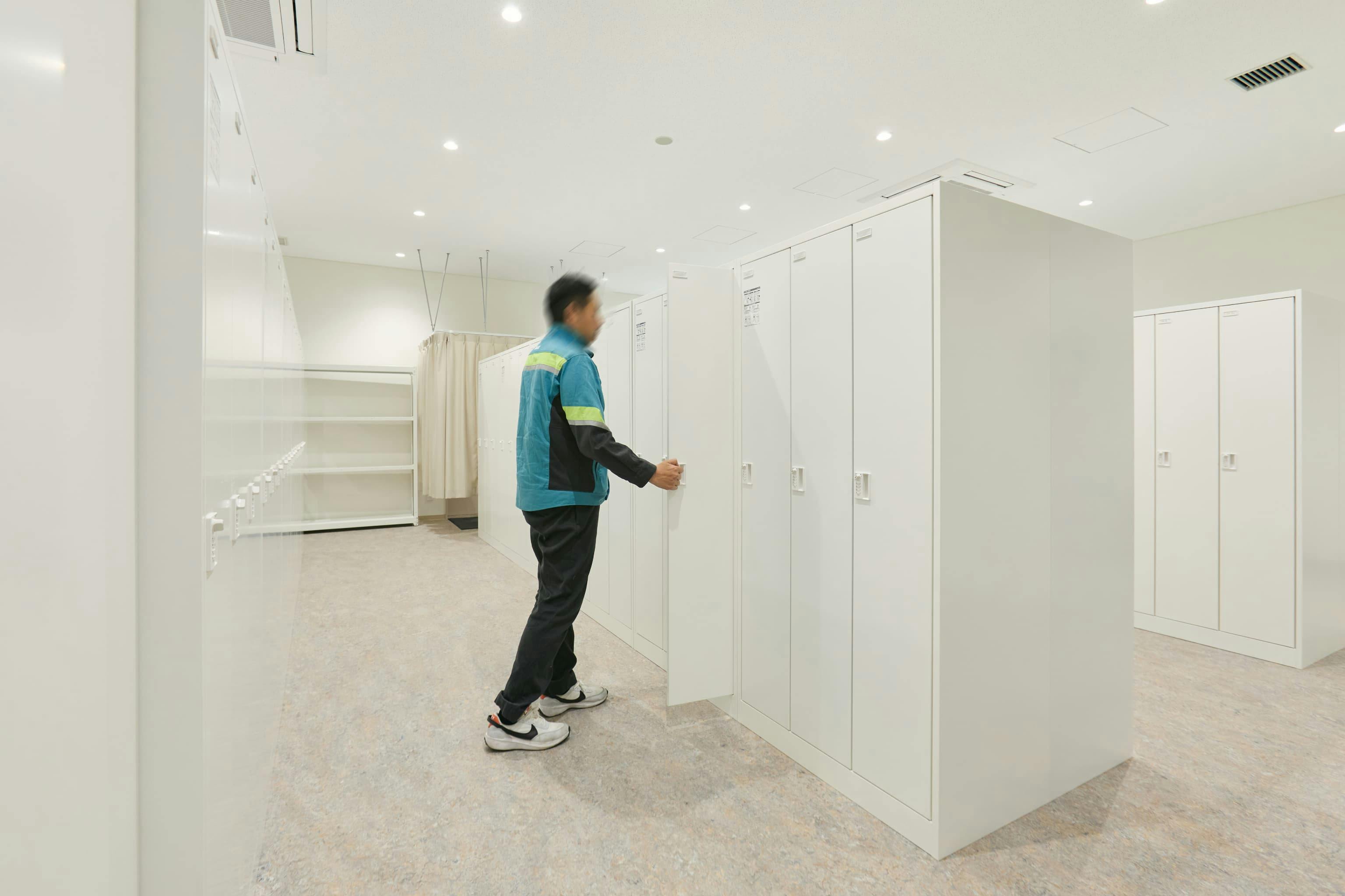 今治造船株式会社 様の事例写真／[1F男性更衣室（オフィス棟）]オフィス内には、広くて清潔な更衣室もあります。汗をかいたときや服が汚れたときなど、作業着以外の着替えに利用。十分なサイズの個人ロッカーが設けられています。