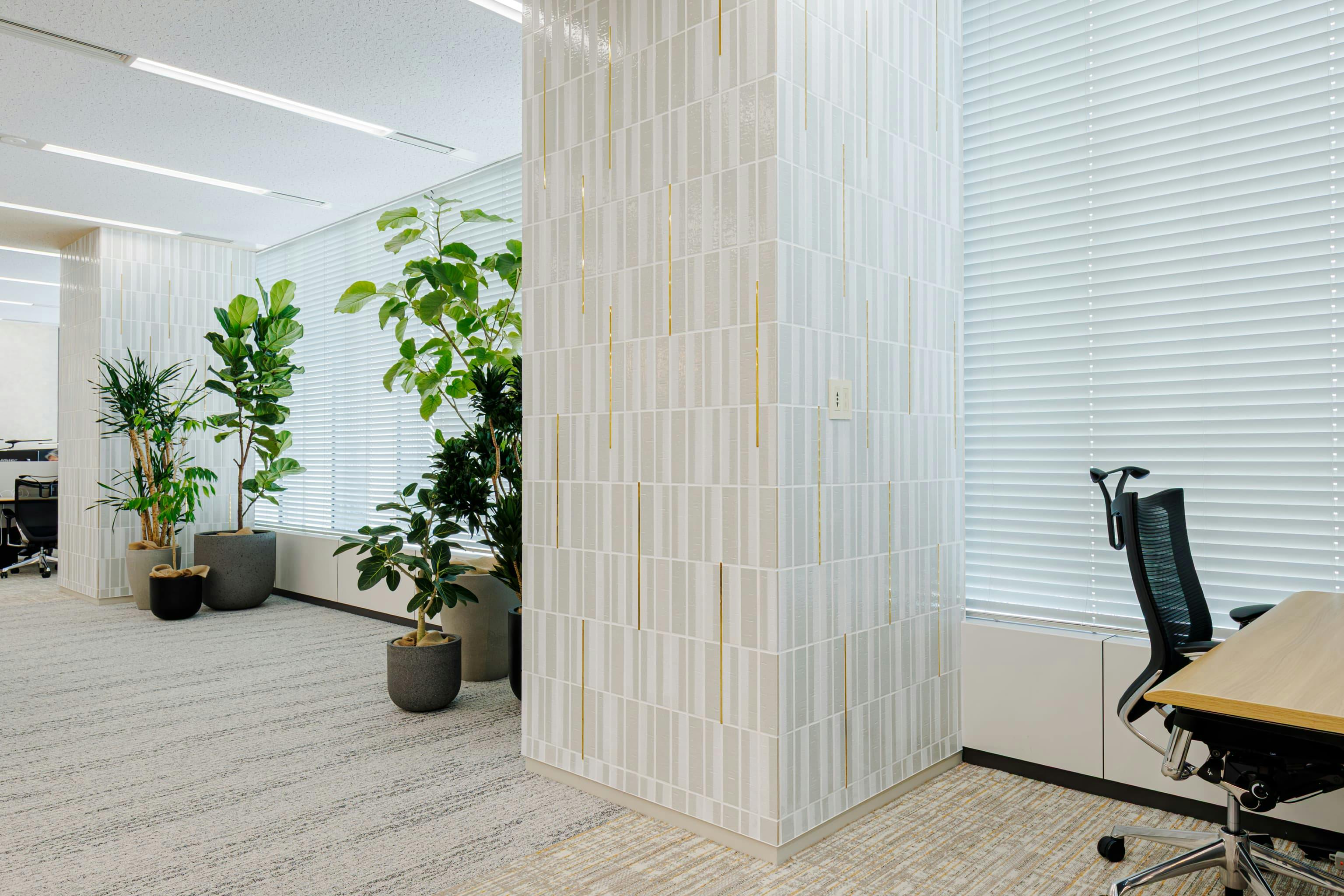 株式会社オカムラ 名古屋ラボオフィス『Cent Labo』の事例写真／[ランウェイエリア]北東の窓面にある大きな2本の柱は、日ごろ商業施設の設計に関わるメンバーのアイデアを取り入れた装飾性がポイント。白いタイルに金色の目地棒が施され、すっきりとしながらも安心感のある雰囲気が演出されています。