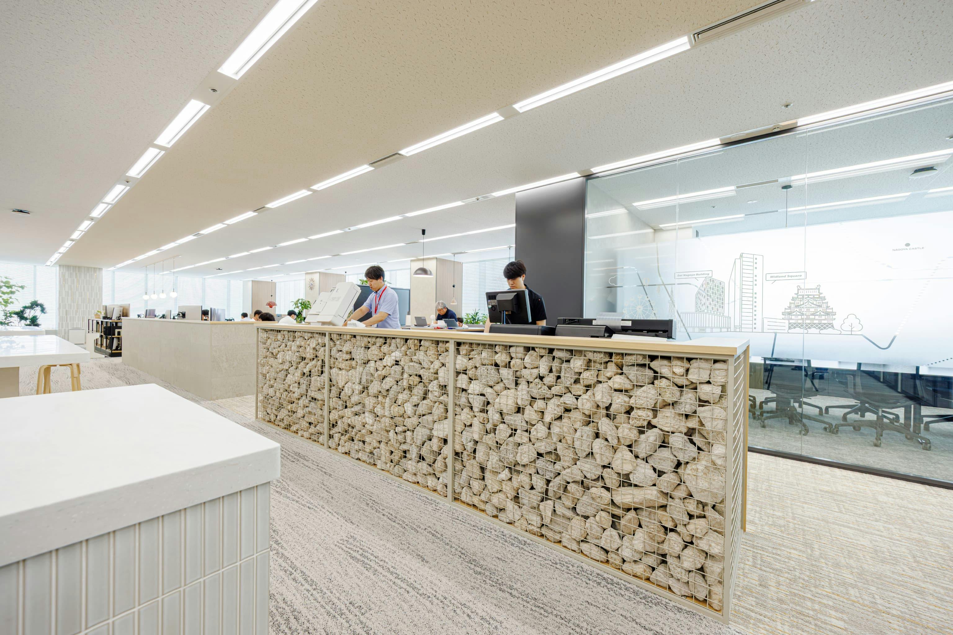 株式会社オカムラ 名古屋ラボオフィス『Cent Labo』の事例写真／[コピーエリア]カタログ作業スペースの付近には、プリンターや事務用品の収納棚を設置。廃棄となったワイヤー什器と白い軽石を塗装し、棚の壁面として再利用しています。