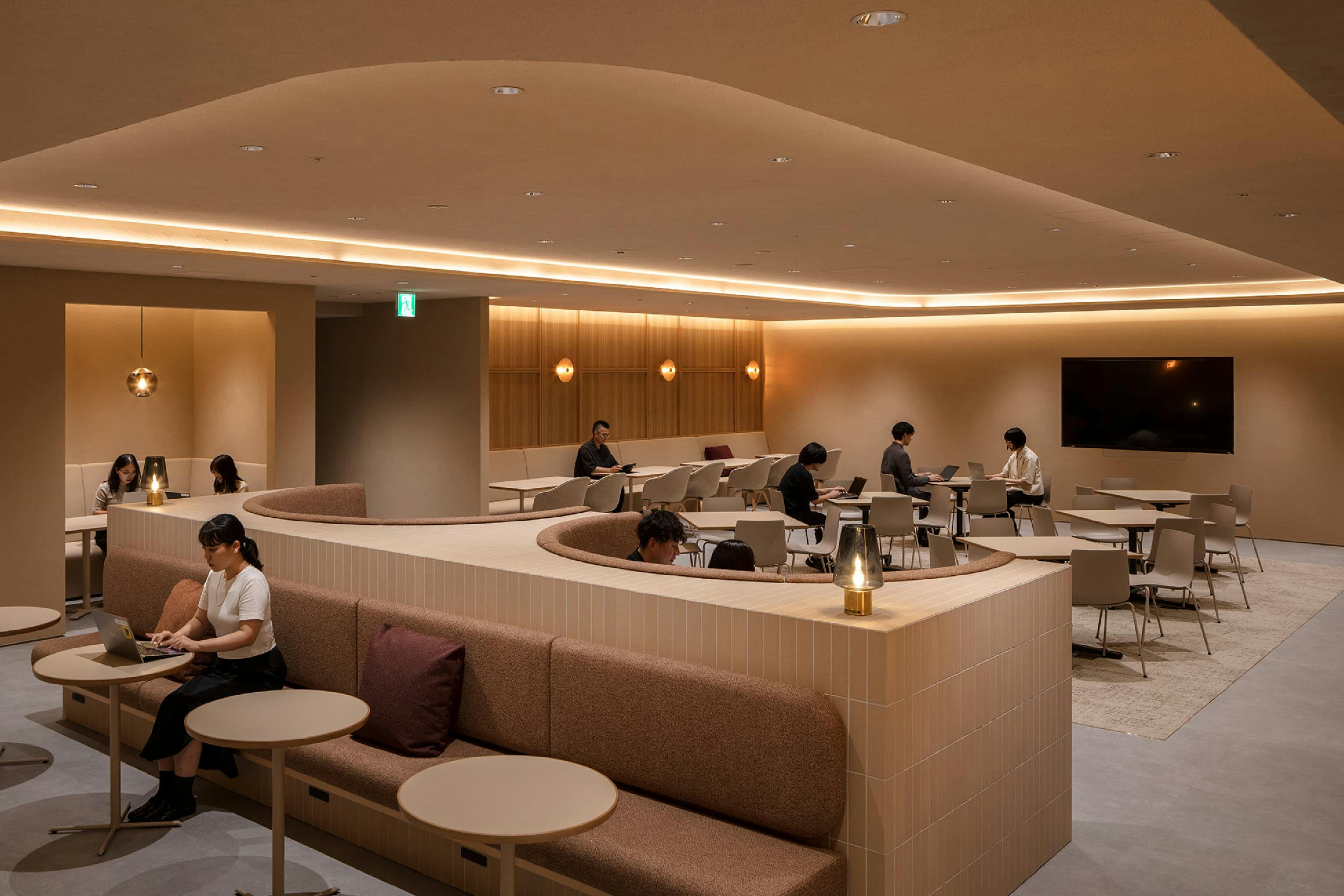 東映株式会社 様の事例写真／[9階 ワークエリア]エントランスの先にはワークエリアが広がっています。なじみのよいアースカラーでまとめられ、穏やかな雰囲気を醸し出します。来客対応はもちろん、社員の作業スペースとしても活用されています。