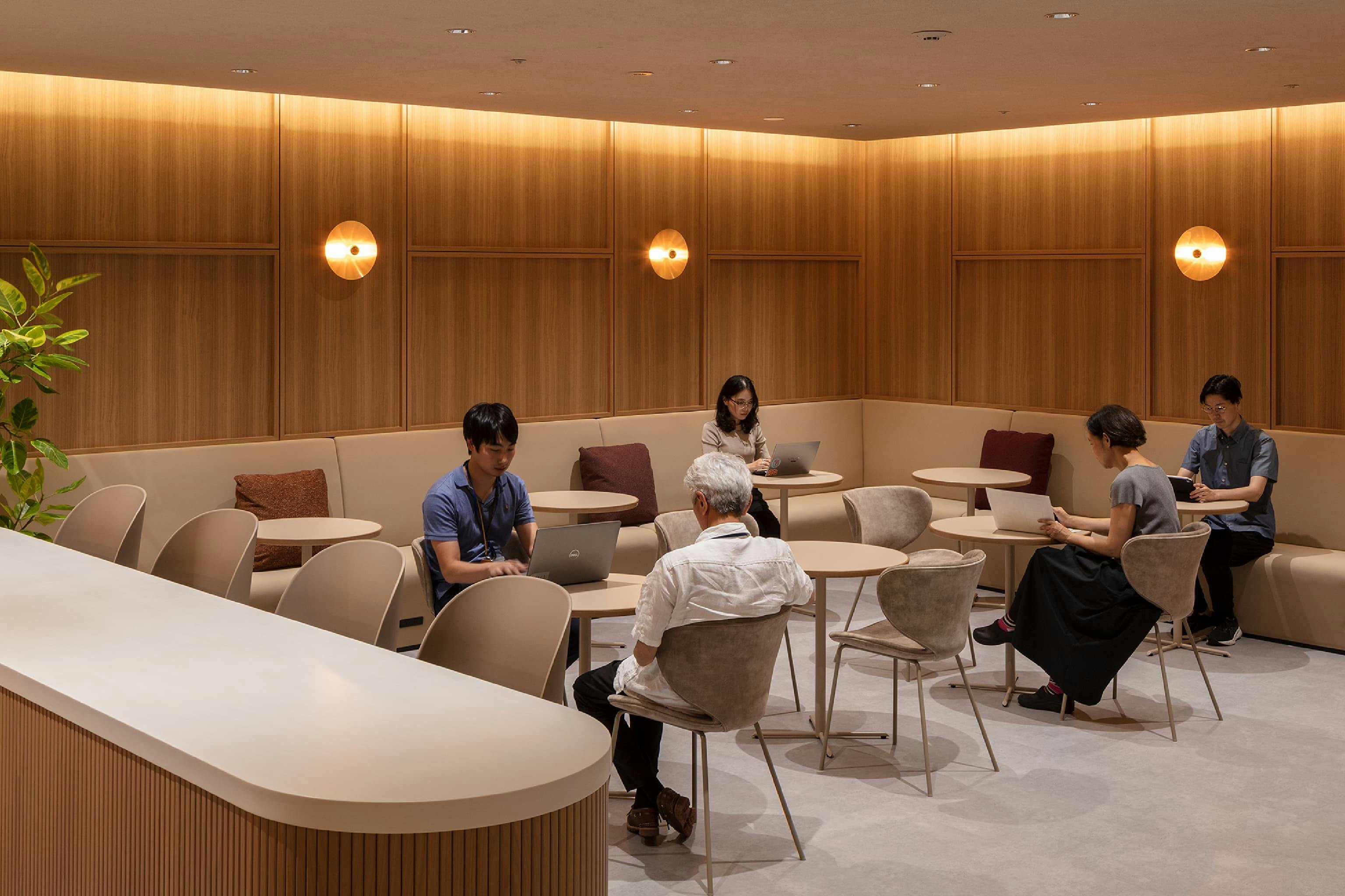 東映株式会社 様の事例写真／[9階 カフェエリア]木目の壁と柔らかな間接照明に包まれたカフェエリアの一角。コーヒーを片手にひと息つける、この落ち着いた空間が今後どんな使われ方をしていくのか楽しみな場所です。