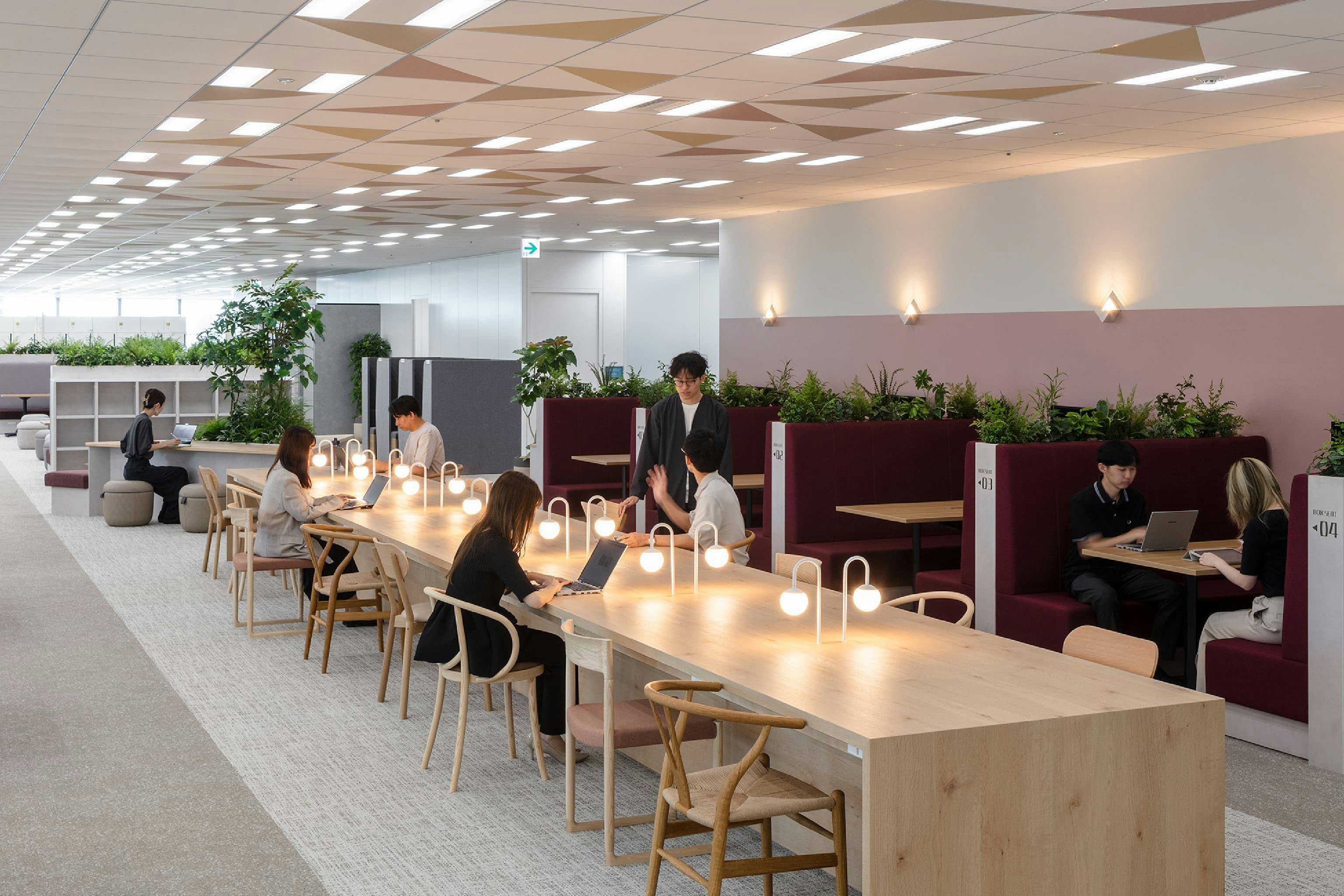 東映株式会社 様の事例写真／[10階 コミュニケーションエリア]天井にあしらわれた三角形の柄は、この場所がコミュニケーションエリアであることを示し、同時に「ここにいる時は話しかけてOK」という視覚的なサインの役割も。やわらかな灯りと相まって、声をかけやすくなったと好評です。