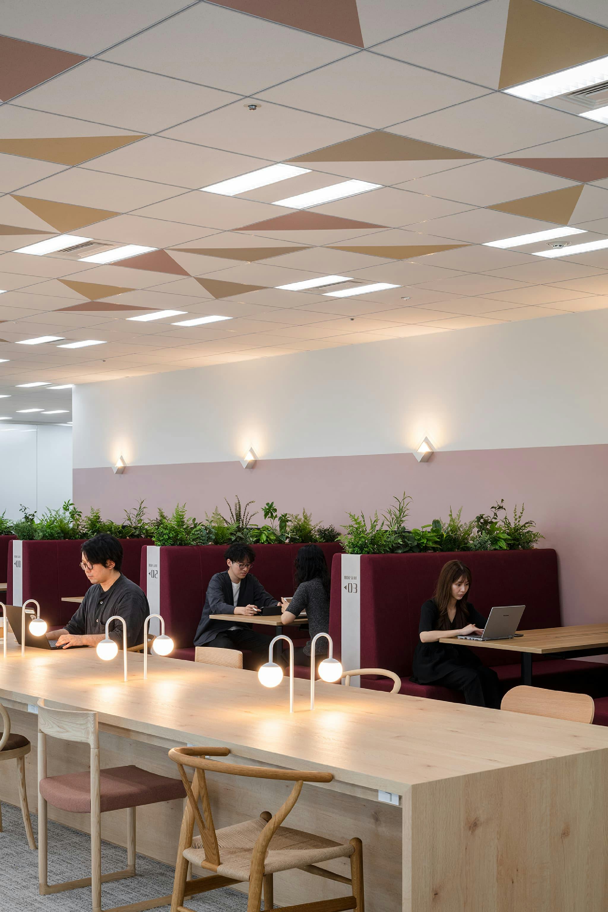 東映株式会社 様の事例写真／[10階 コミュニケーションエリア]コーポレートカラーのボルドーを取り入れたファミレス席が、空間に落ち着きをもたらしています。このエリアで交わされる会話は周辺の社員にも程よく伝わり、自然な情報共有とゆるやかなつながりが生まれます。