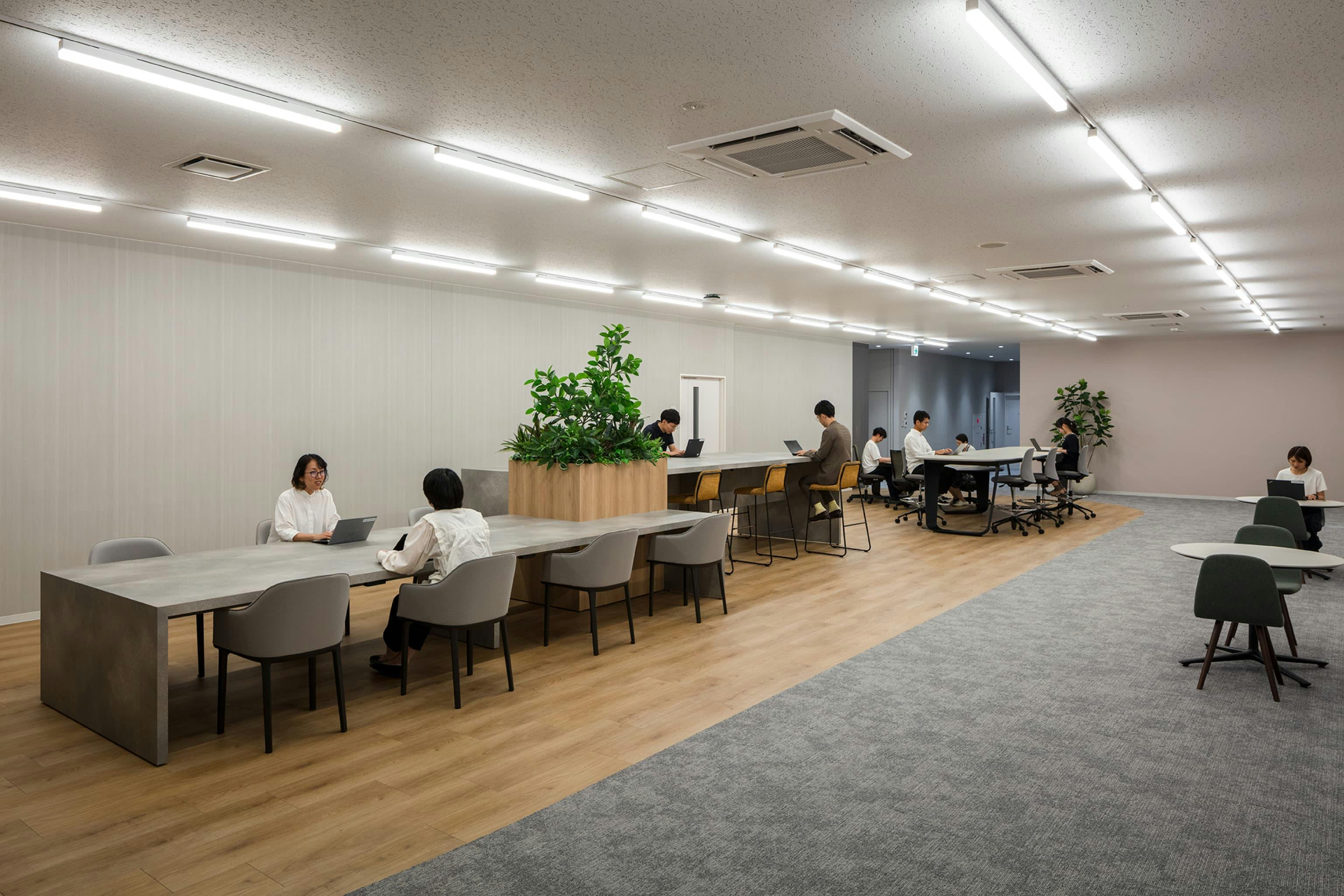 第一法規株式会社 様の事例写真／[１Fワークラウンジ]商談スペースに隣接するワークラウンジは、様々な利用シーンを想定してつくられた空間。資料確認スペースをはじめ、執務作業や社内ミーティングなどにも活用されています。