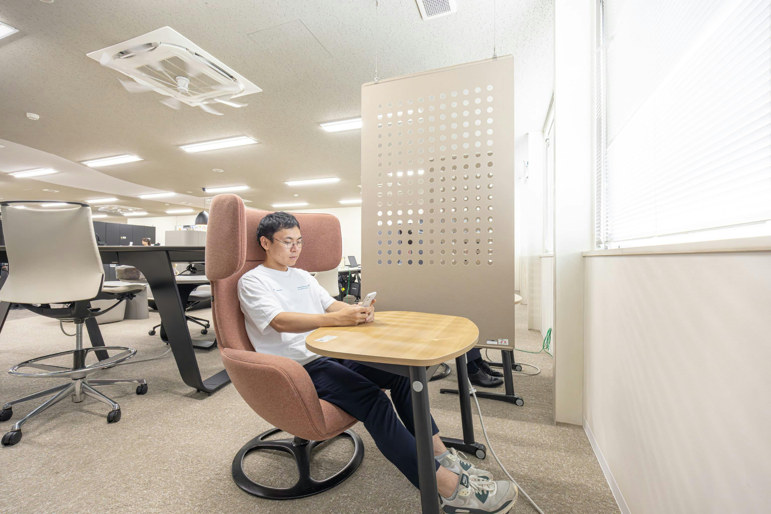 日本ガスケット株式会社 様の事例写真／[執務エリア]役員席の反対側に位置する窓際には、籠り感のあるチェアを並べた集中席が並んでいます。フェルト素材の軽やかな吊り下げ式パネルで、周りの視線をほどよく遮っています。