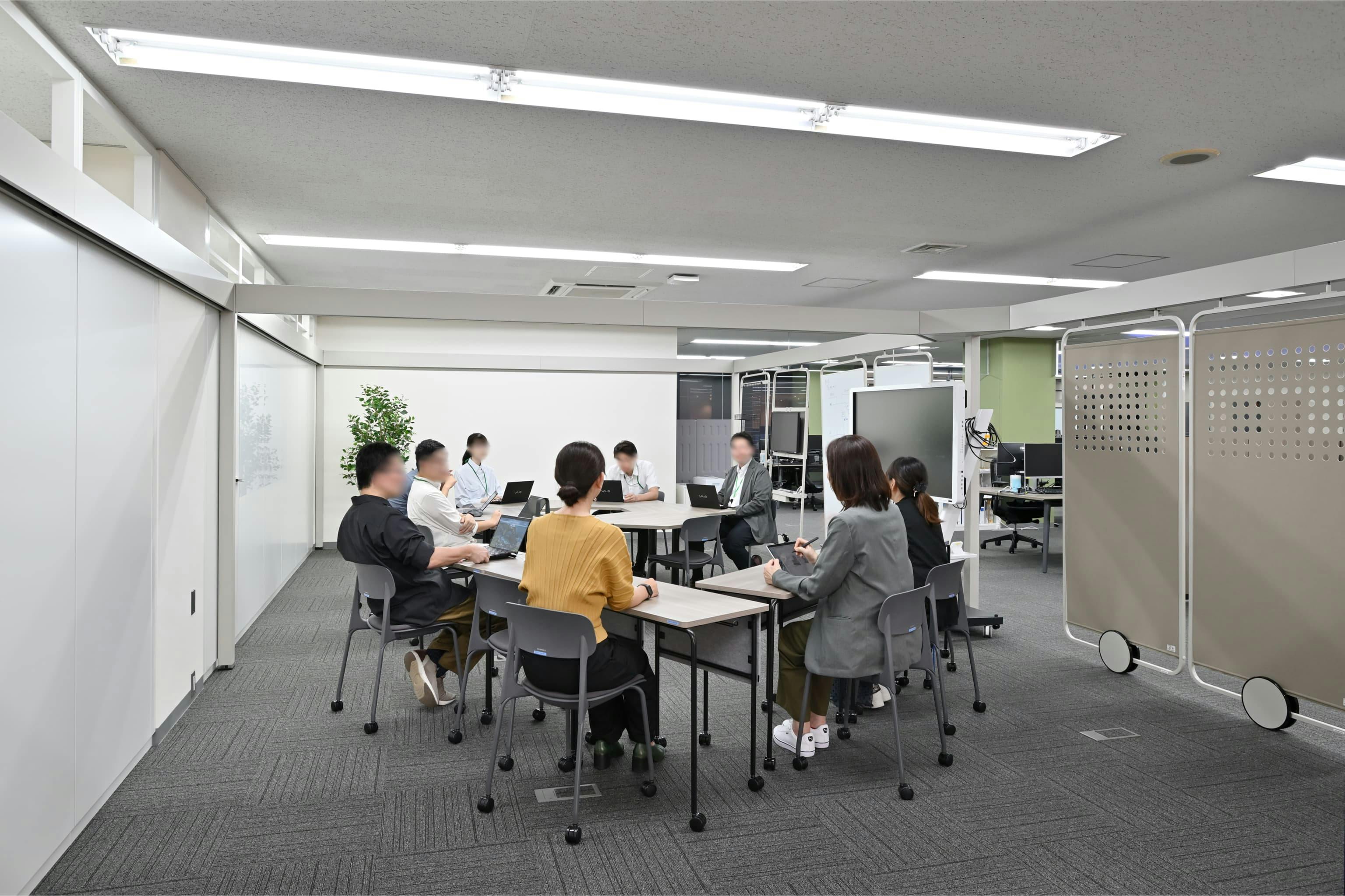 株式会社エスケイケイ 様の事例写真／[やぐらスペース]音や視線をほどよく遮るパネルを移動させれば、セミクローズドな空間に。カジュアルな意見交換からフォーマルな技術発表会まで幅広く対応できる、柔軟な協働の場です。ここから新しい価値の創出が期待されています。