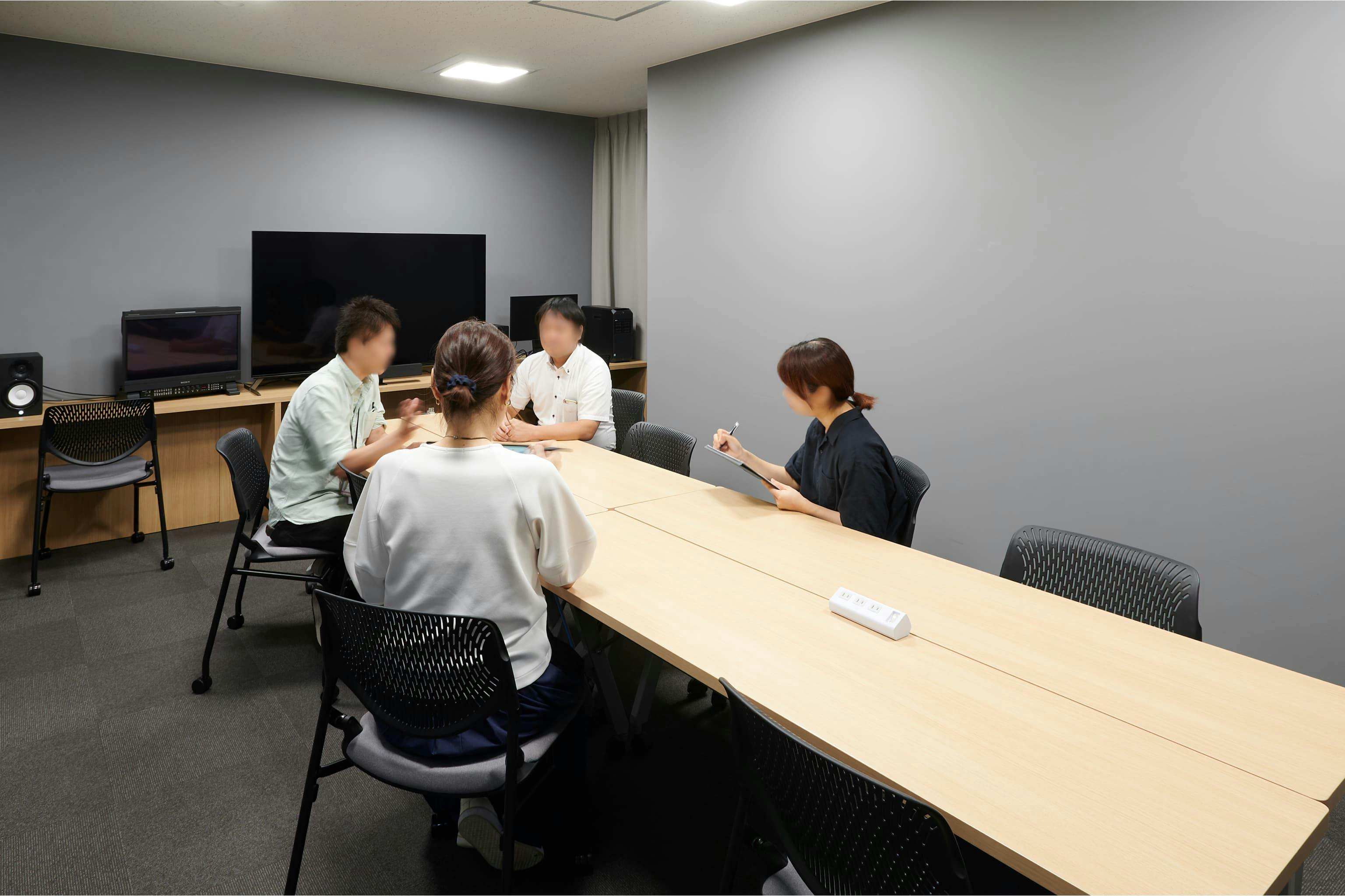 株式会社A-1 Pictures 様の事例写真／[N棟3Fラッシュルーム兼会議室]映像をチェックするラッシュルームは、会議室を兼ねています。グレーの壁で光の反射を抑え、遮音材で音環境にも配慮。映像確認と打ち合わせを同時進行できて利便性が増したほか、会議室不足も解消したと喜ばれています。