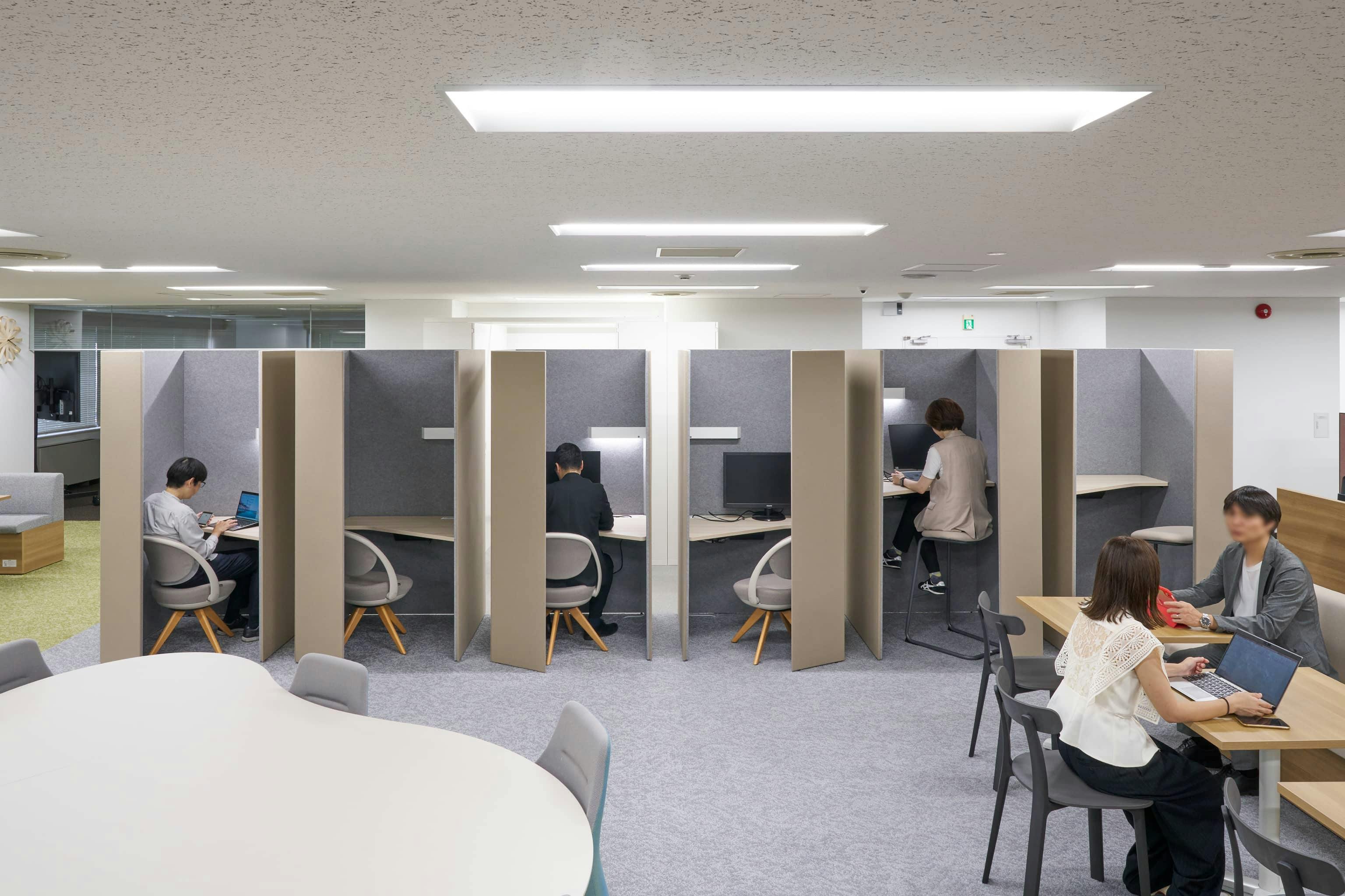 ジェイエスフィット株式会社 様の事例写真／[7F ABWエリア]セミクローズタイプのブースは集中したいときに最適。周囲の視線と音を気にせず、作業に没頭できます。Webミーティングや個人作業に活用され、気分や好みに合わせて天板の高さをハイタイプとロータイプから選べます。