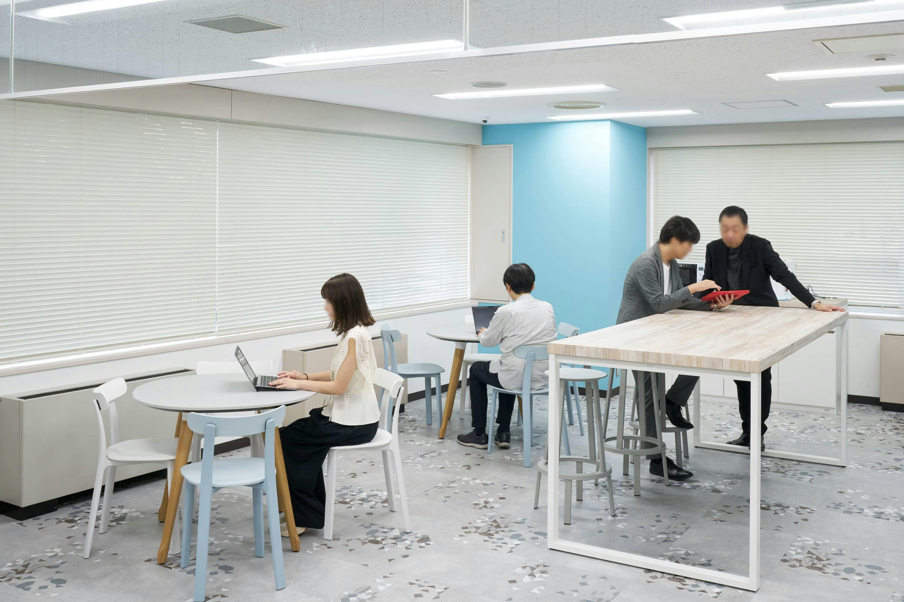 ジェイエスフィット株式会社 様の事例写真／[5Fカフェスペース]ブルーとホワイトを基調にした爽やかな空間。自動販売機や軽食の販売があり、カフェスペースとして親しまれています。ランチタイムや合間の気分転換に別フロアから訪れる社員が多く、交流の場になっています。