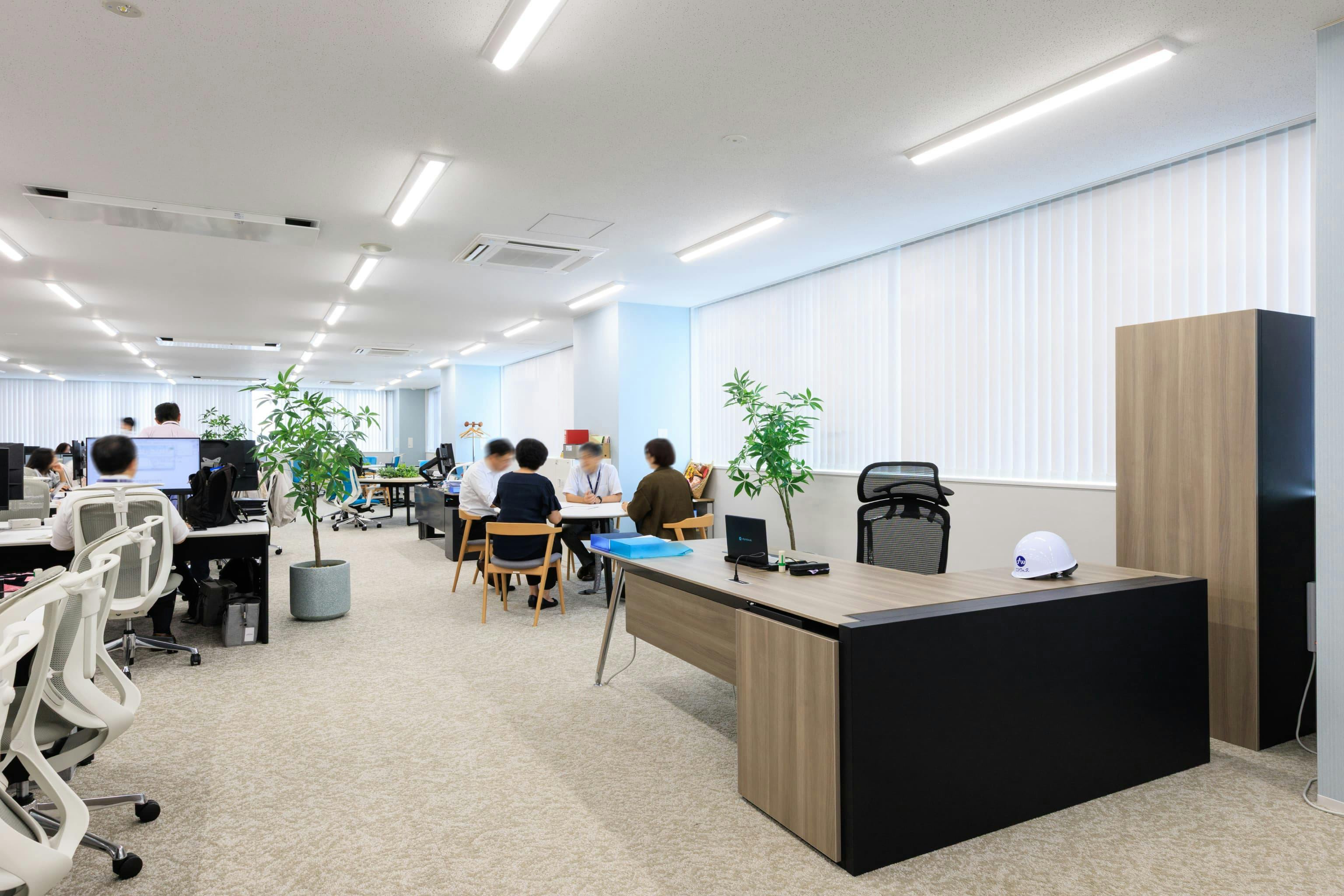 エア・ウォーター・エンジニアリング株式会社 様の事例写真／[5F社長席]社長室を設けず、社員とコミュニケーションをとりやすいオープンな空間に社長席があります。そばに置かれた木製の丸テーブル席は、社長を交えた話し合いに活用。柔らかな印象で、リラックスした雰囲気が演出されています。