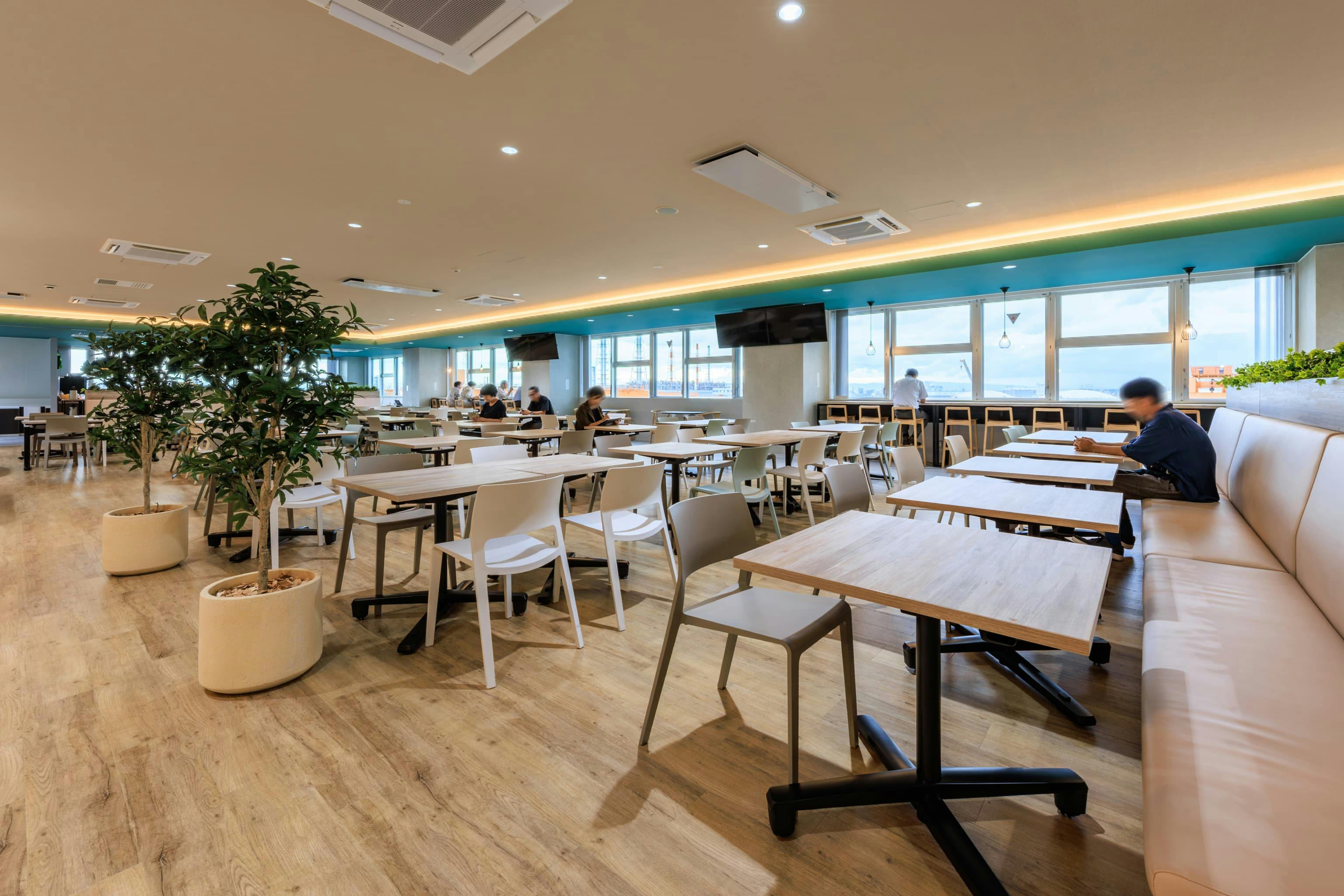 エア・ウォーター・エンジニアリング株式会社 様の事例写真／[6F食堂]フロア中央は2人用のテーブル席をベースに構成し、個人利用による1卓あたりの空席を減らします。隣のテーブルと合わせて、4人以上のグループ席をつくることも可能。ベンチシートの座面下には備品を収納できます。
