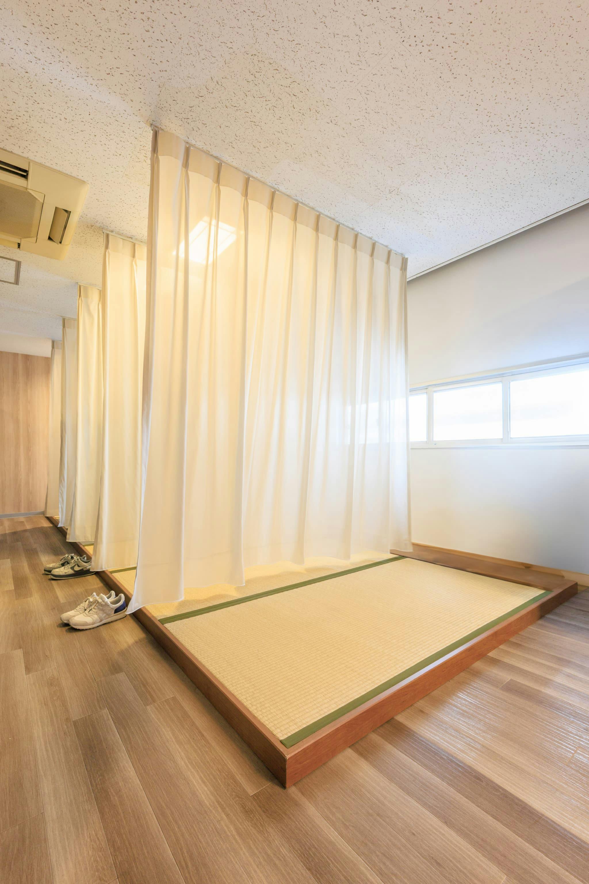 TOPPAN株式会社 ／ TOPPANパッケージプロダクツ株式会社 様の事例写真／[食堂上休憩エリア 畳スペース]しっかりと横になれる畳スペース。以前は背の低いパネルで仕切っていましたが、天井からカーテンを吊るすスタイルに変更。より落ち着ける空間となりました。