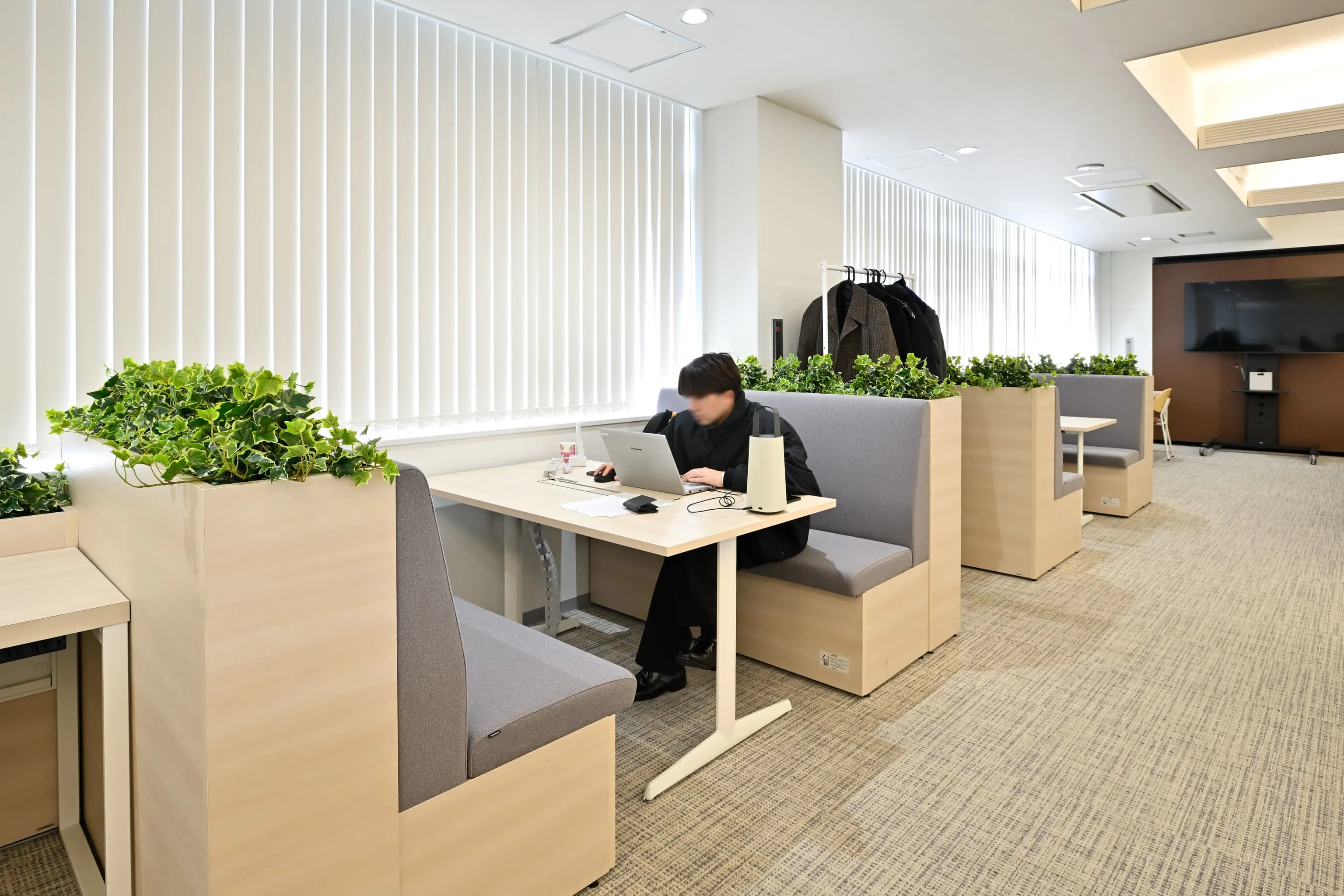 株式会社岡本工作機械製作所 様の事例写真／[2F執務エリア]ファミレス席は資料を広げた作業や少人数での打ち合わせに活用されています。OCポータブルバッテリーにより電源位置を気にせず作業が可能に。働き方に寄り添う設計が、柔軟なワークスタイルと業務効率の向上を支えています。