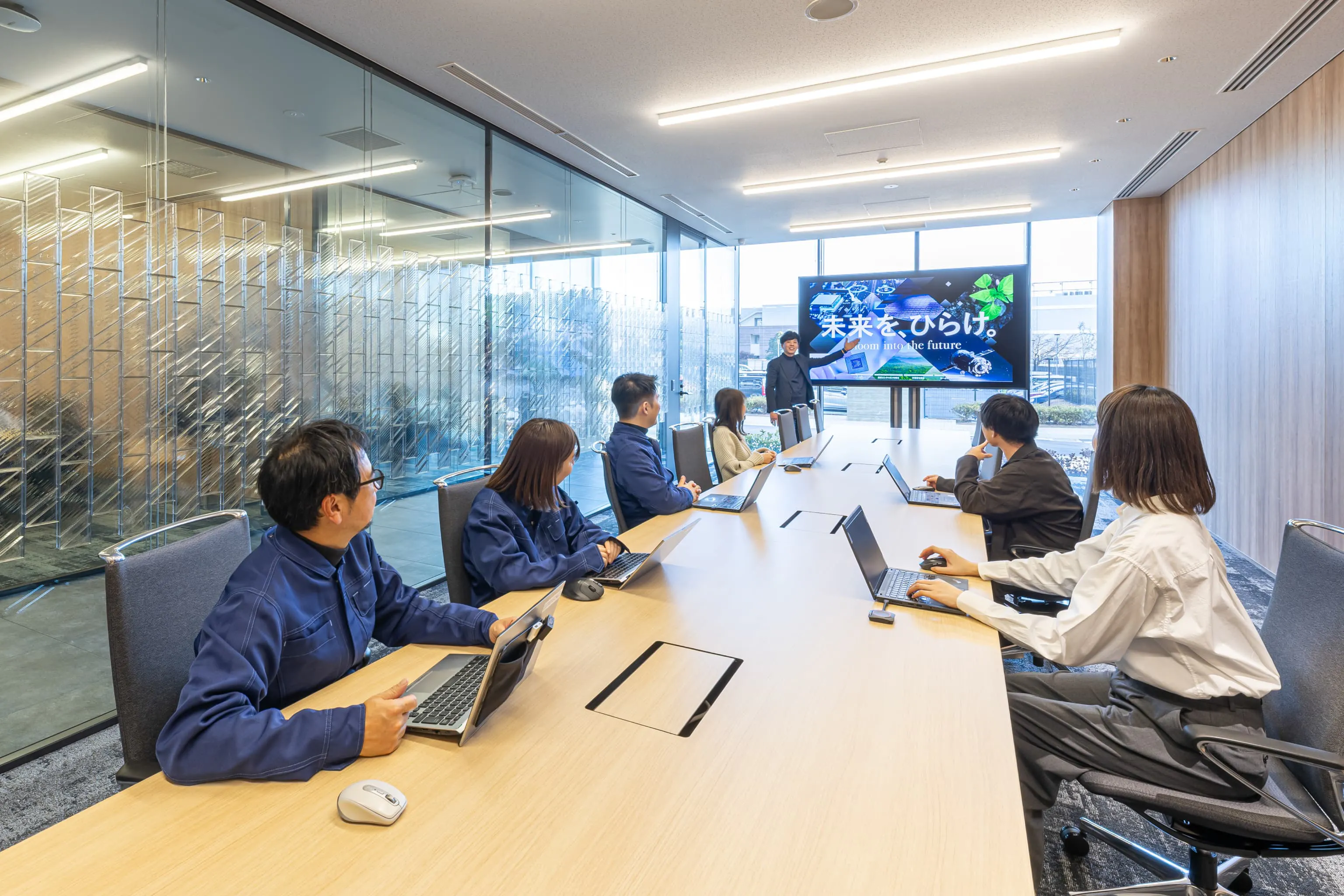 東京エレクトロン九州株式会社 様の事例写真／[1F応接室]エントランスホールの周辺には、来客用の応接室が３室用意されています。インテリアは重厚感を重視。グレーの張地にアルミのフレームの椅子が、高級感がありながら、背もたれが薄くすっきりとした印象を与えています。