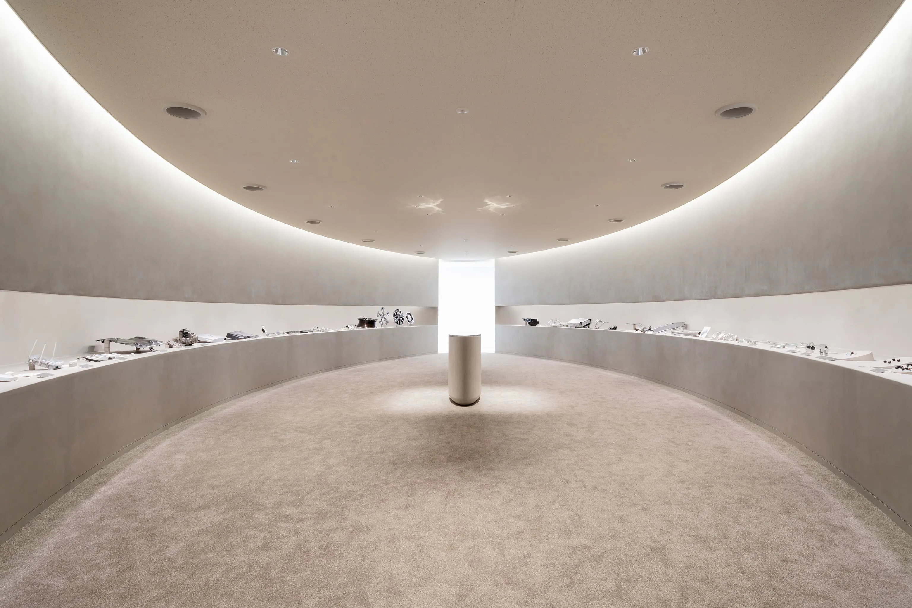 太平洋工業株式会社 様の事例写真／[1F Oval Gallery]船底のような曲線を描くデザインのギャラリーでは、全事業部の現行製品を展示しています。中央には、創業時に作られたバルブコアを埋め込んだオーバル型のテーブルも。