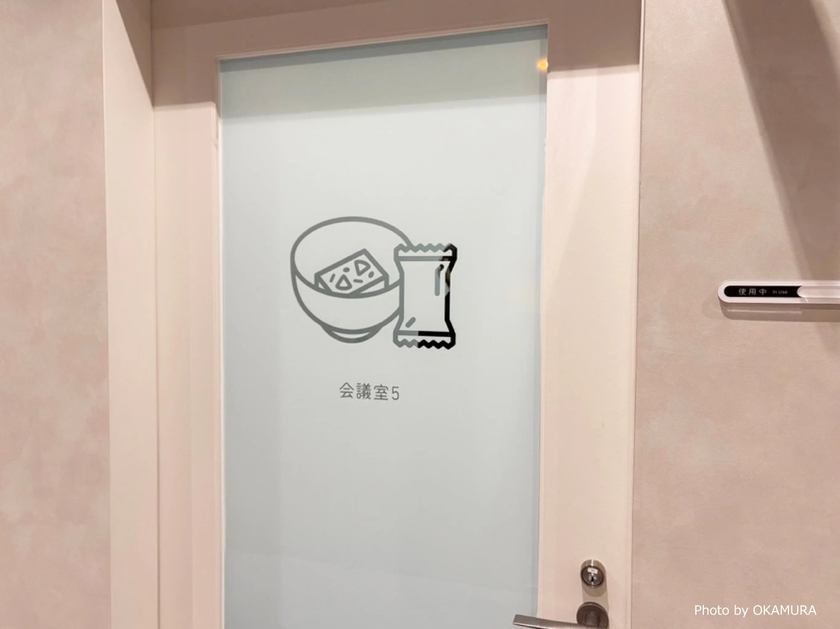 アサヒグループ食品株式会社 様の事例写真／[会議室のサイン]会議室のサインには、自社商品をモチーフにしたイラストが添えられています。サインごとに異なる商品が描かれ、来訪者との会話のきっかけに。社員にとっても、商品への親しみが湧く工夫です。