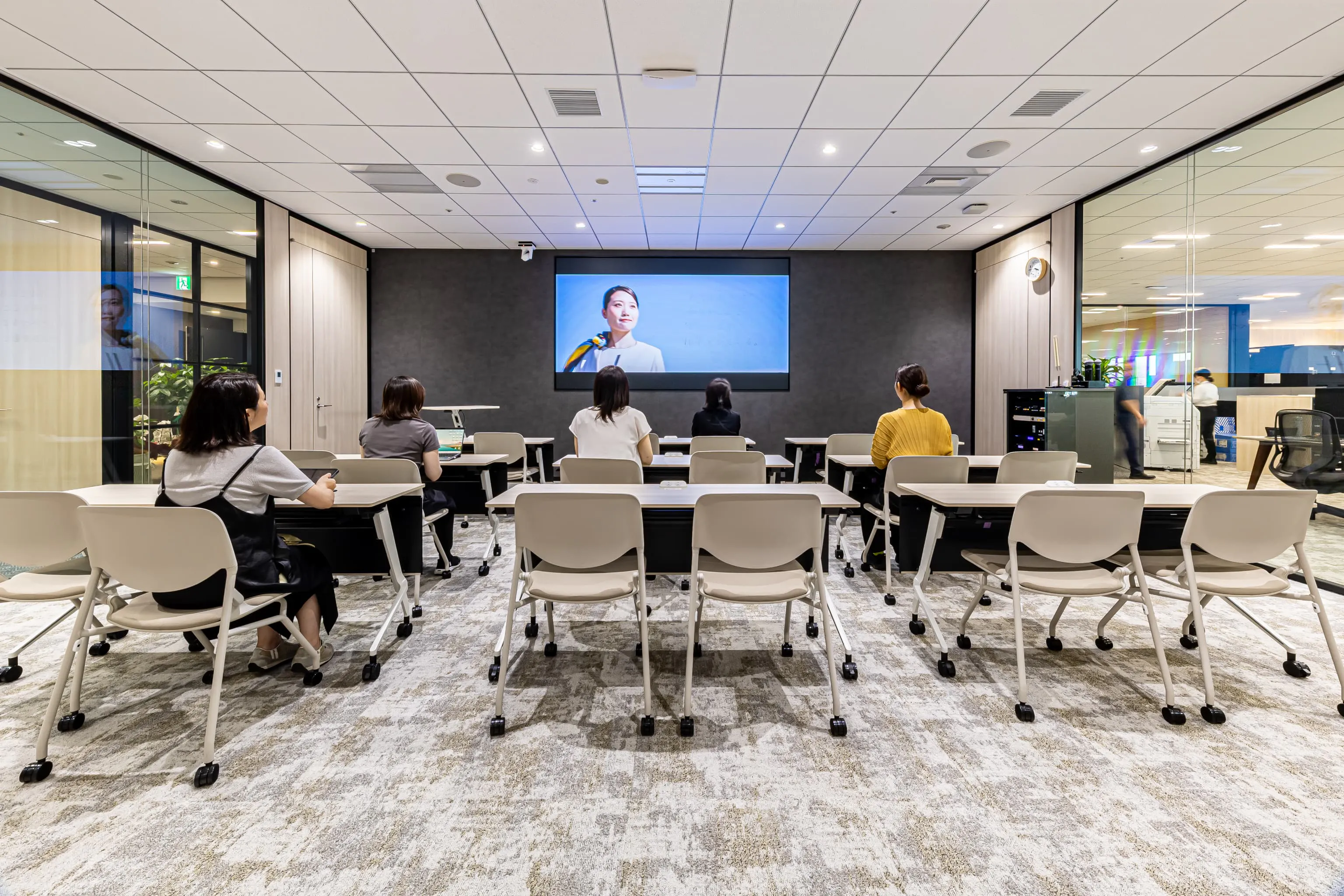 西鉄エアサービス株式会社 様の事例写真／[Conference Room]最大50名を収容できるConference Roomは、入社式や研修など多目的に利用されています。ガラス壁にすることで組織内の透明性を確保。一方で機密性の高い会議にも対応できるよう、カーテンも設置されています。