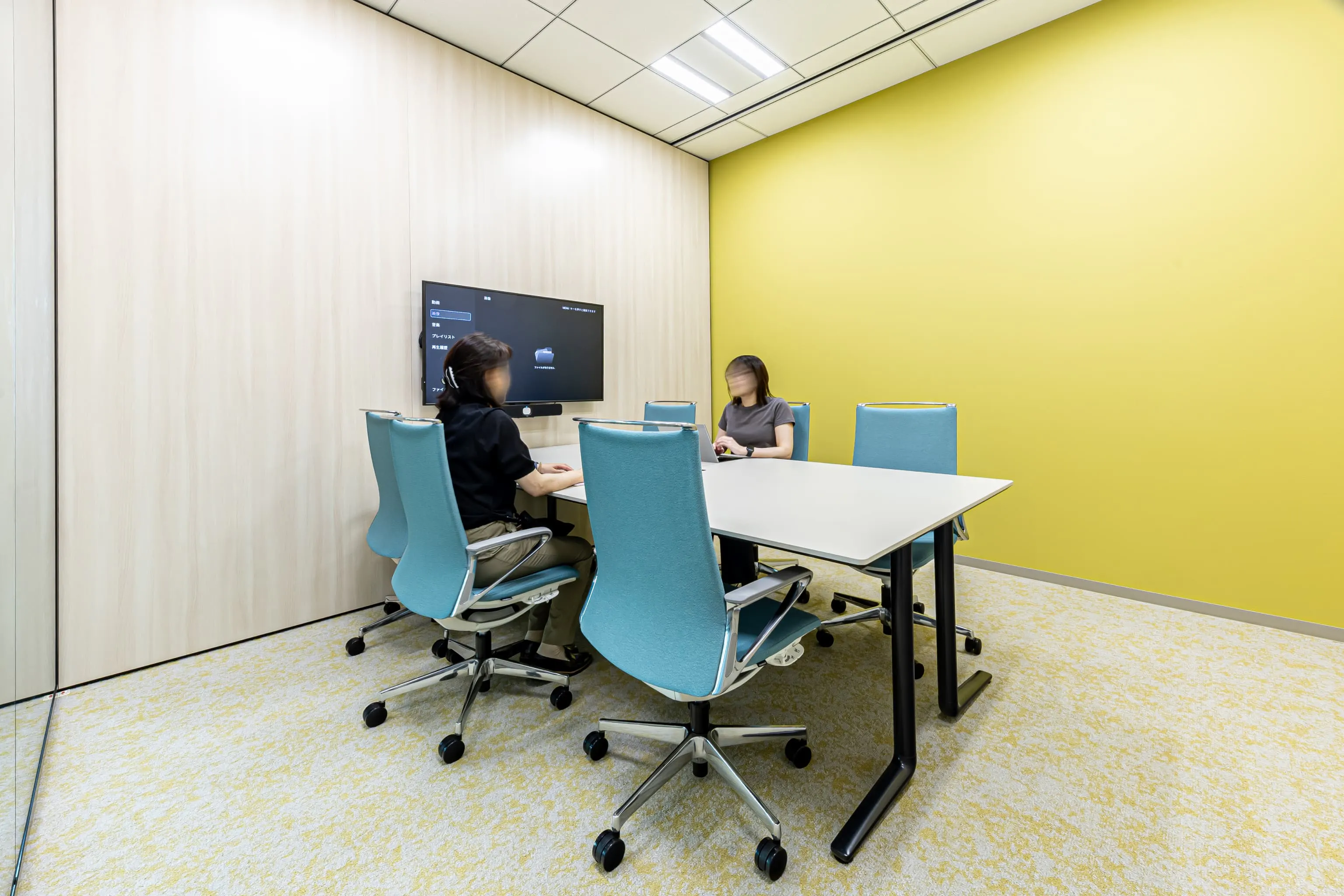西鉄エアサービス株式会社 様の事例写真／[Meeting Room]旧オフィスでの会議室不足を解消し、急な来客や面談に対応できるようにMeeting Roomを増設。部屋ごとにコーポレートカラーを取り入れた壁紙を採用し、色鮮やかで明るい空間が緊張感を和らげています。