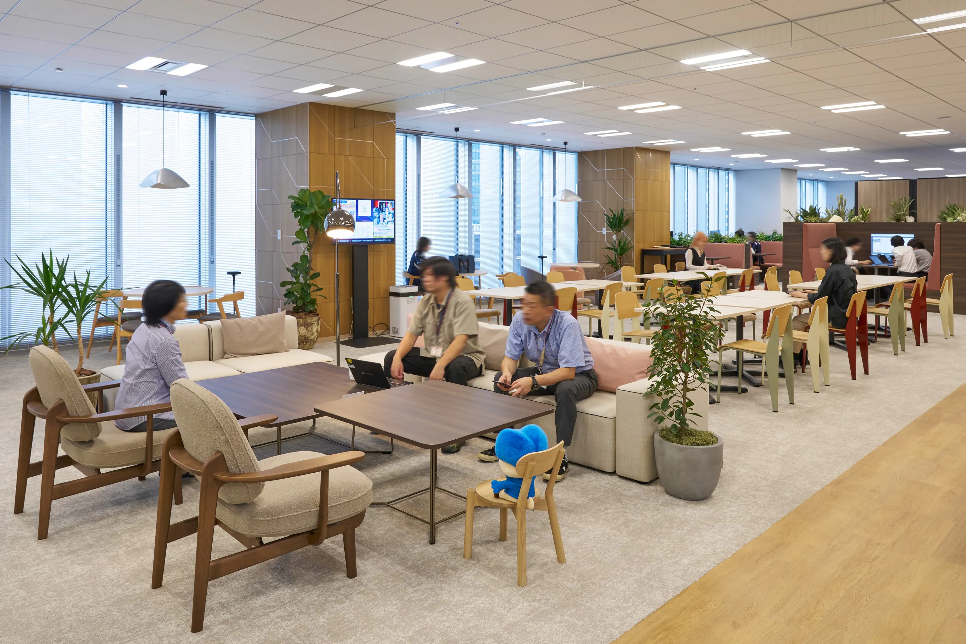 三菱電機エンジニアリング株式会社 様の事例写真／[10FCozy Café]過ごし方に合わせて、ソファ席やテーブル席など自由に選べます。観葉植物に囲まれたリラックスした雰囲気で、仕事の合間にも立ち寄りやすく、会話が弾むと好評です。