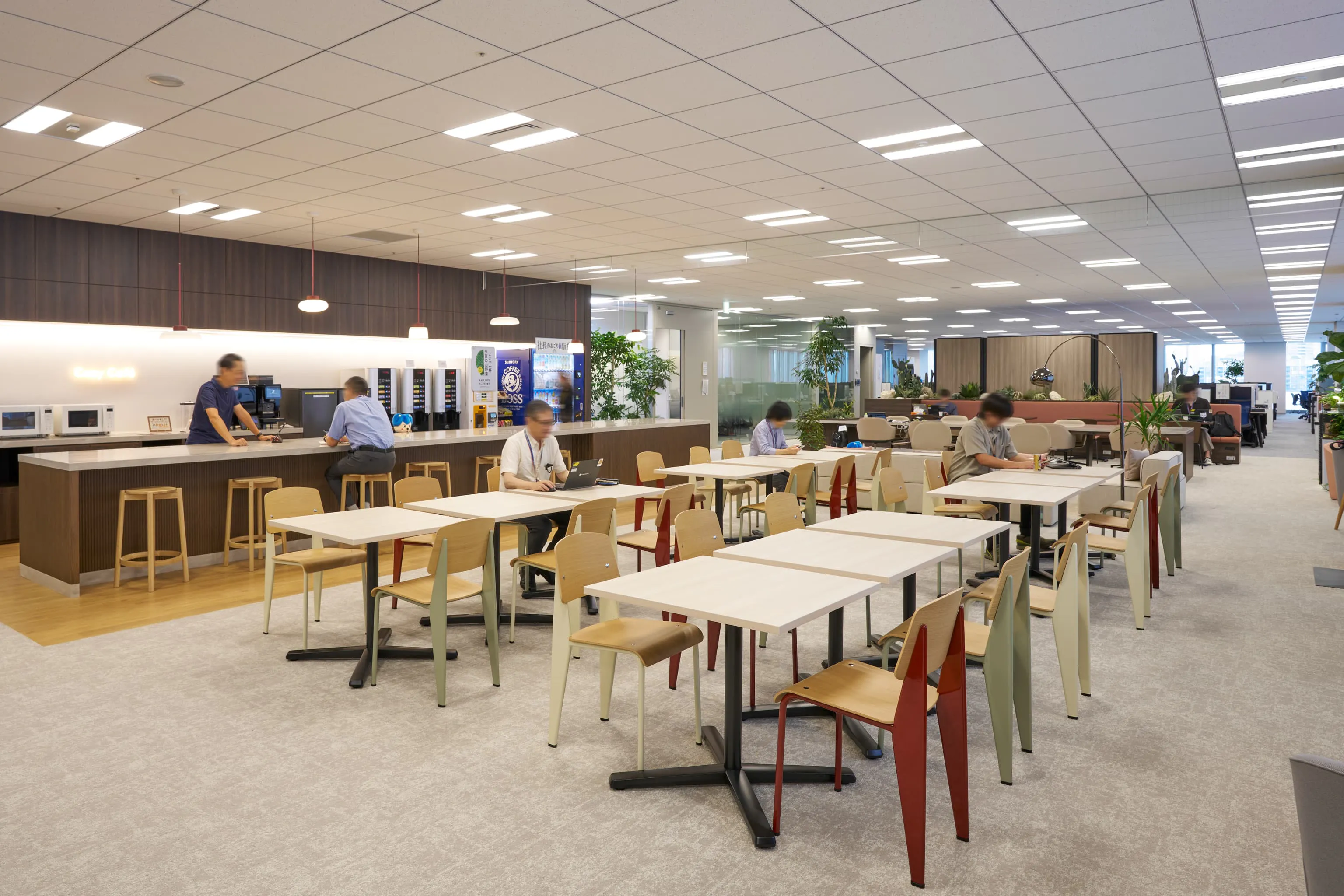 三菱電機エンジニアリング株式会社 様の事例写真／[10FCozy Café]ランチタイムには多くの従業員で賑わうエリア。エンジニアでもあった家具デザイナー、ジャン・プルーヴェのチェアが並び、くつろぎの場にもエンジニアリングへの敬意が感じられます。