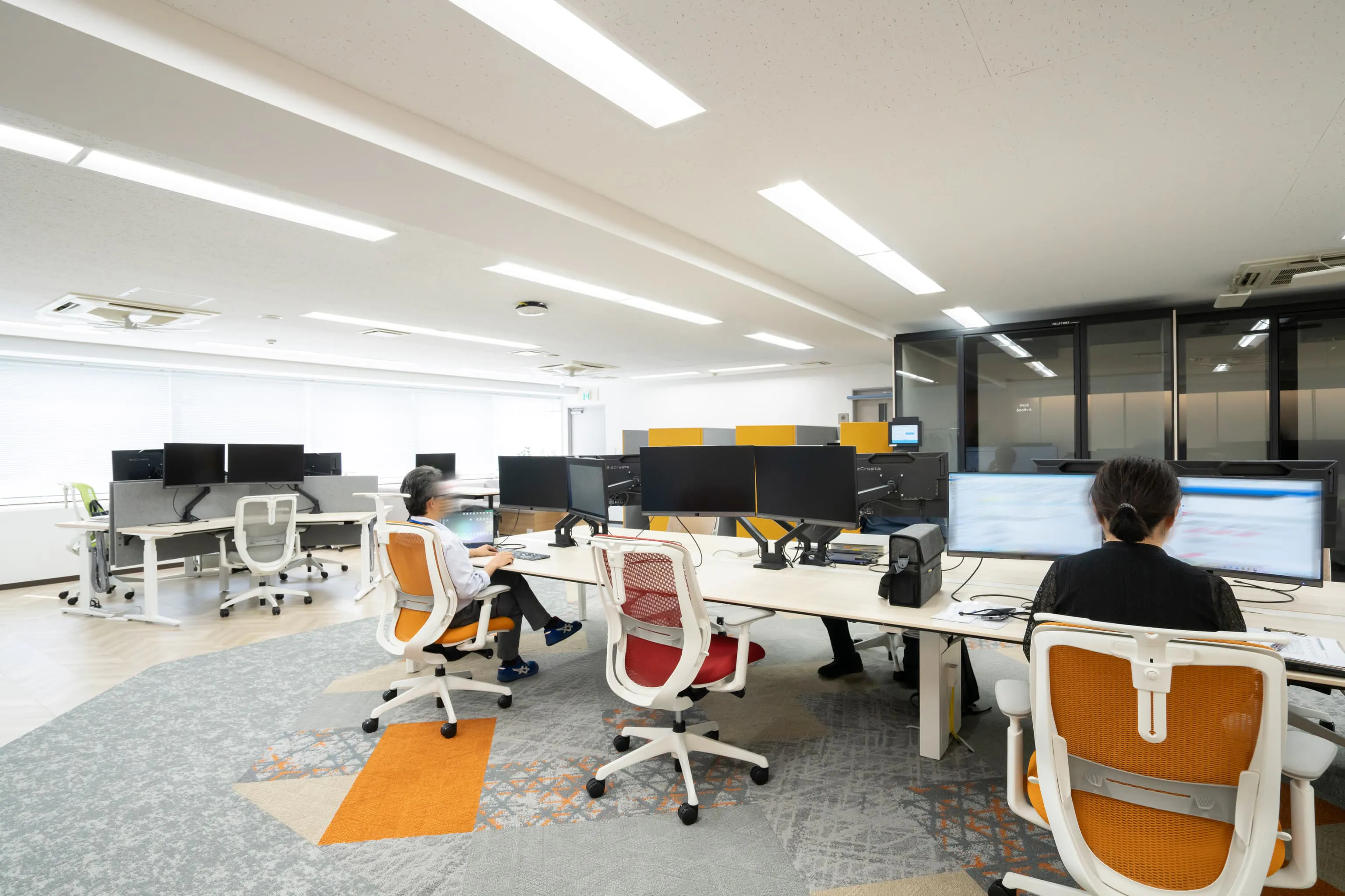 オルガノ株式会社 様の事例写真／[6F執務エリア]6階は「ポップな色を」という従業員の希望により、オレンジを差し色にした温かみのある空間です。電動昇降デスクや図面が見やすい幅広のデスクなど、技術職の作業がはかどる環境が整えられています。