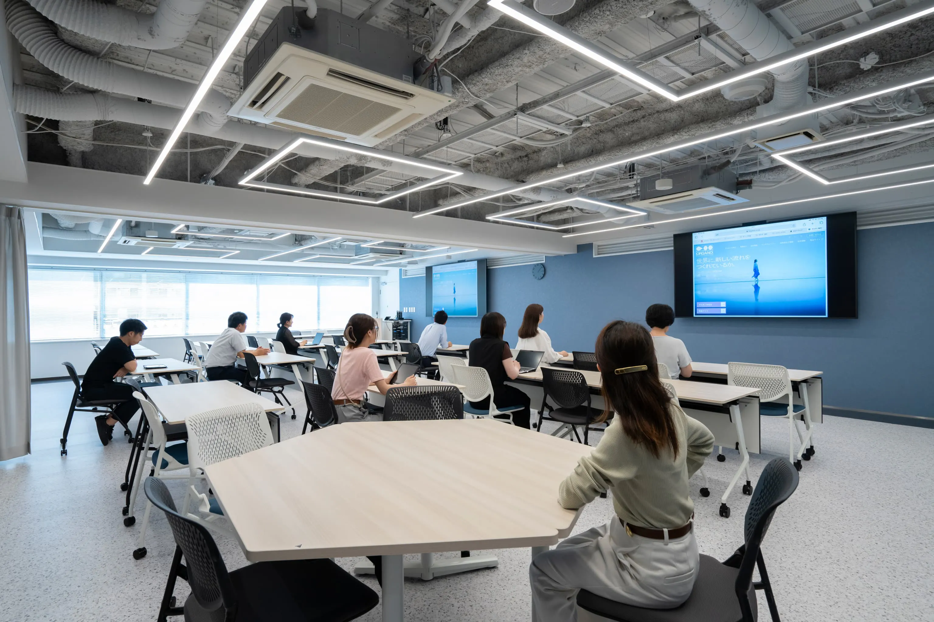 オルガノ株式会社 様の事例写真／[3Fプレゼンテーションルーム]効率的な会議進行のため、音響などの設備も充実。長テーブルのほかに六角形のテーブルが配され、少人数のグループワークなどに活用されています。部屋の中央をカーテンで仕切り、部屋を2分割することも可能です。